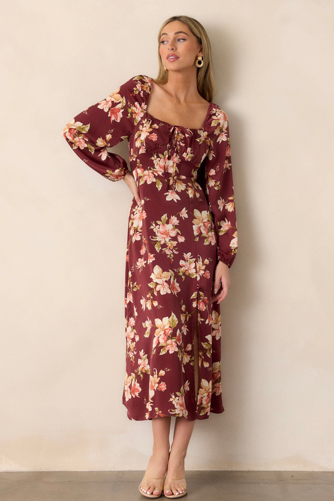 Full-length shot highlighting the long sleeves with elastic cuffs and the stunning floral pattern that adorns the entire dress.
