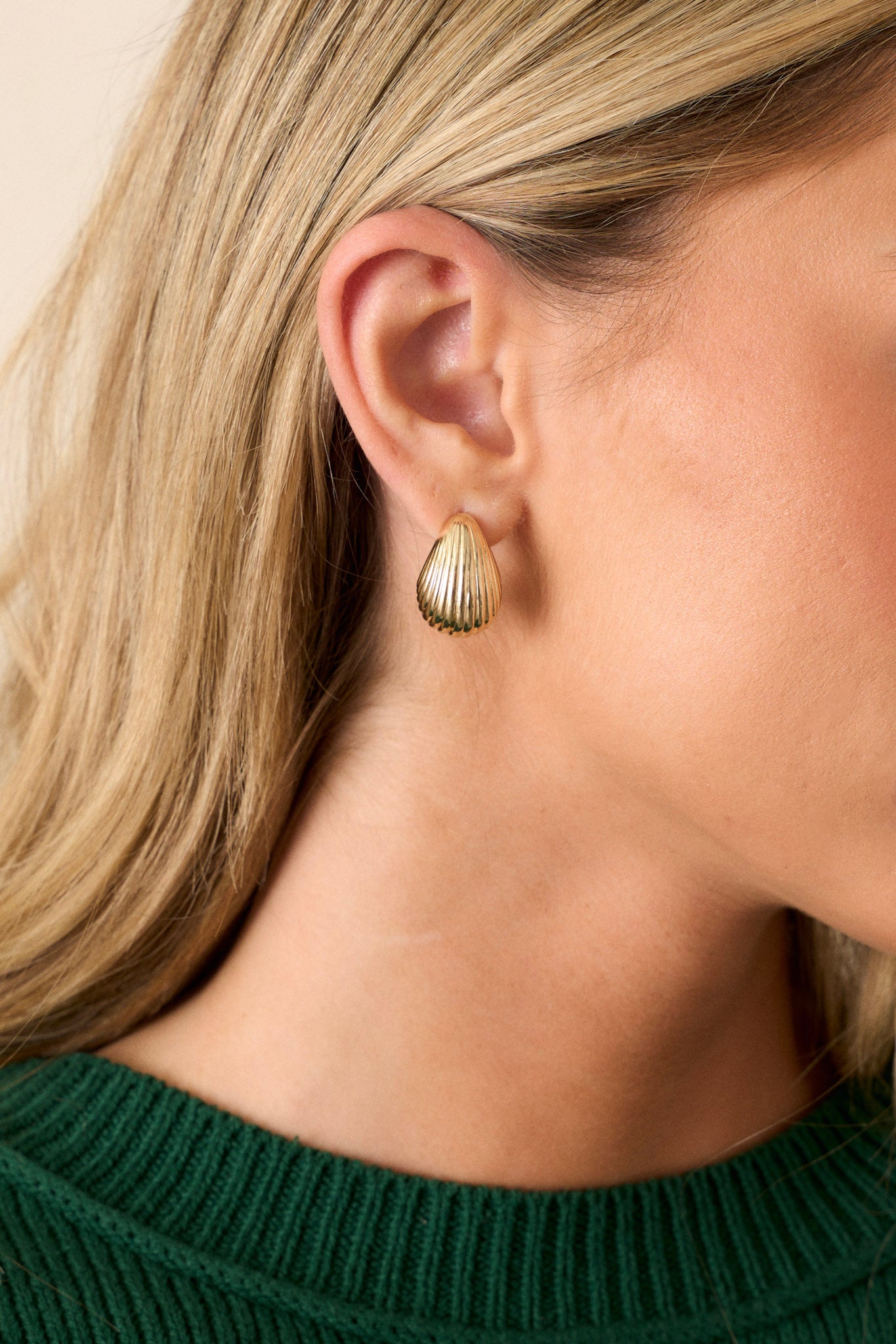 These gold earrings feature gold finish, a teardrop shape, a ripple texture, and secure post hole backings.