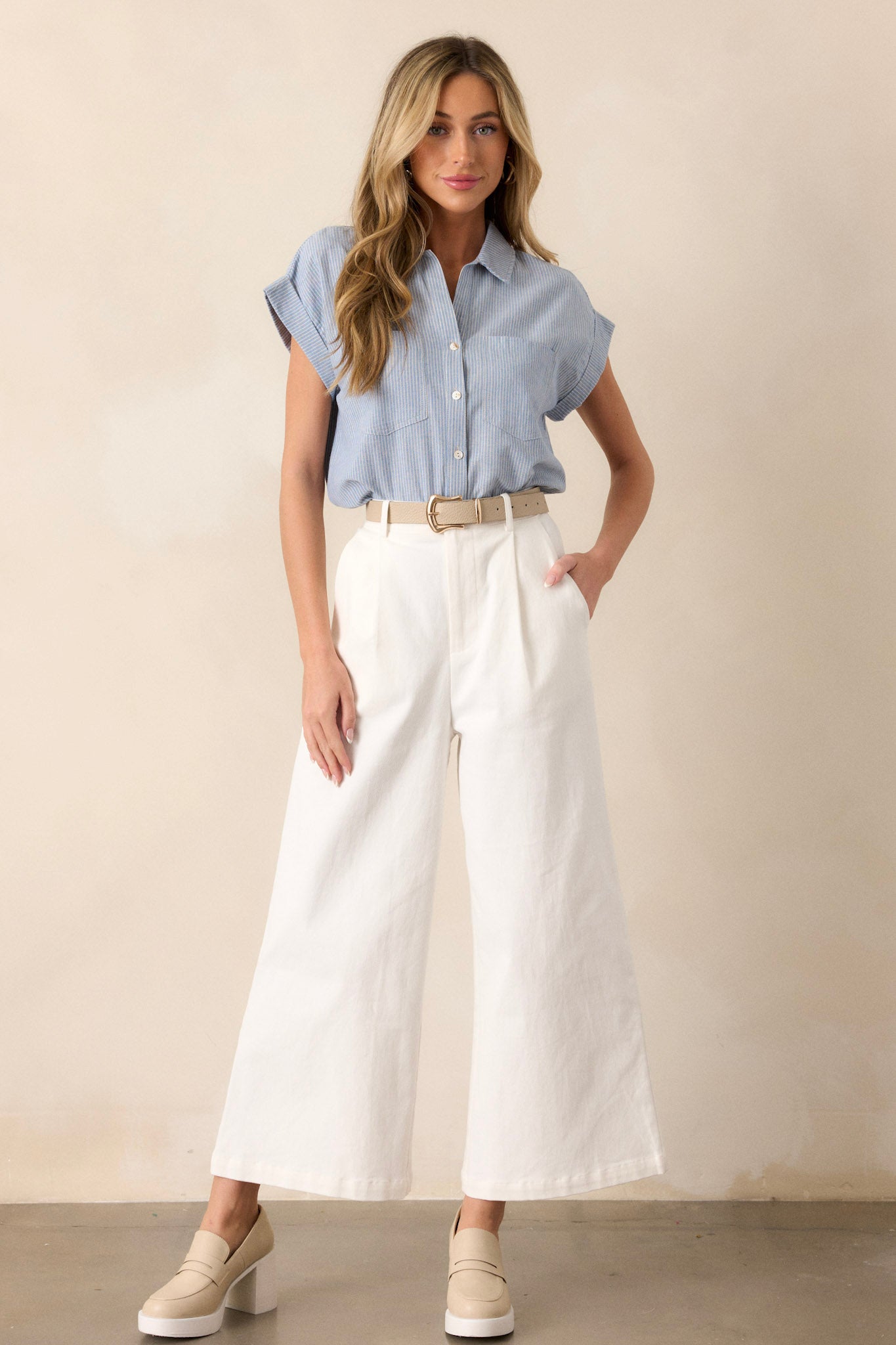 Full length view of the wide leg jeans featuring a high waisted design, elastic waist insert, functional belt loops, button zipper closure, functional hip pockets, and a wide leg
