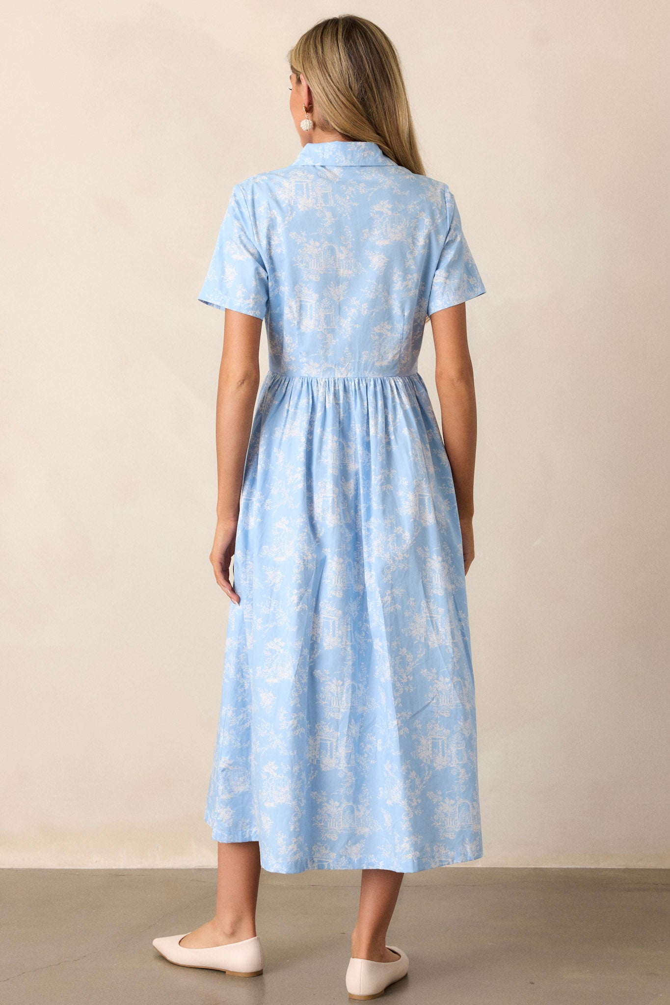 Back view of a light blue maxi dress highlighting the collared neckline, gathering at the waist, and overall fit.