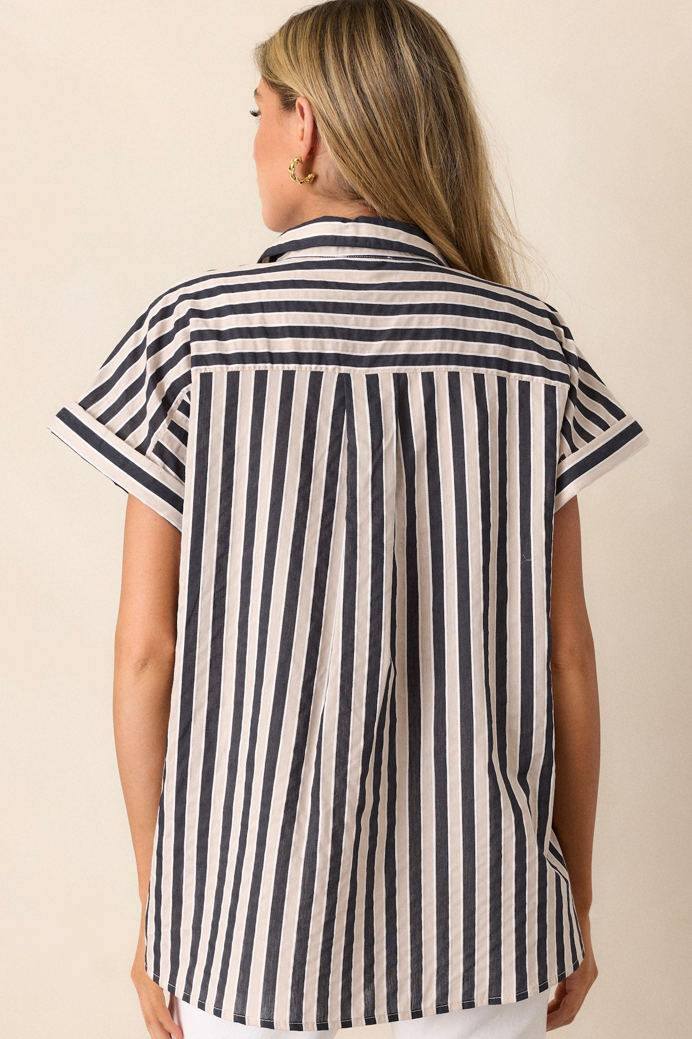 Back view of a black stripe top highlighting the vertical stripe design, cuffed short sleeves, and overall fit.