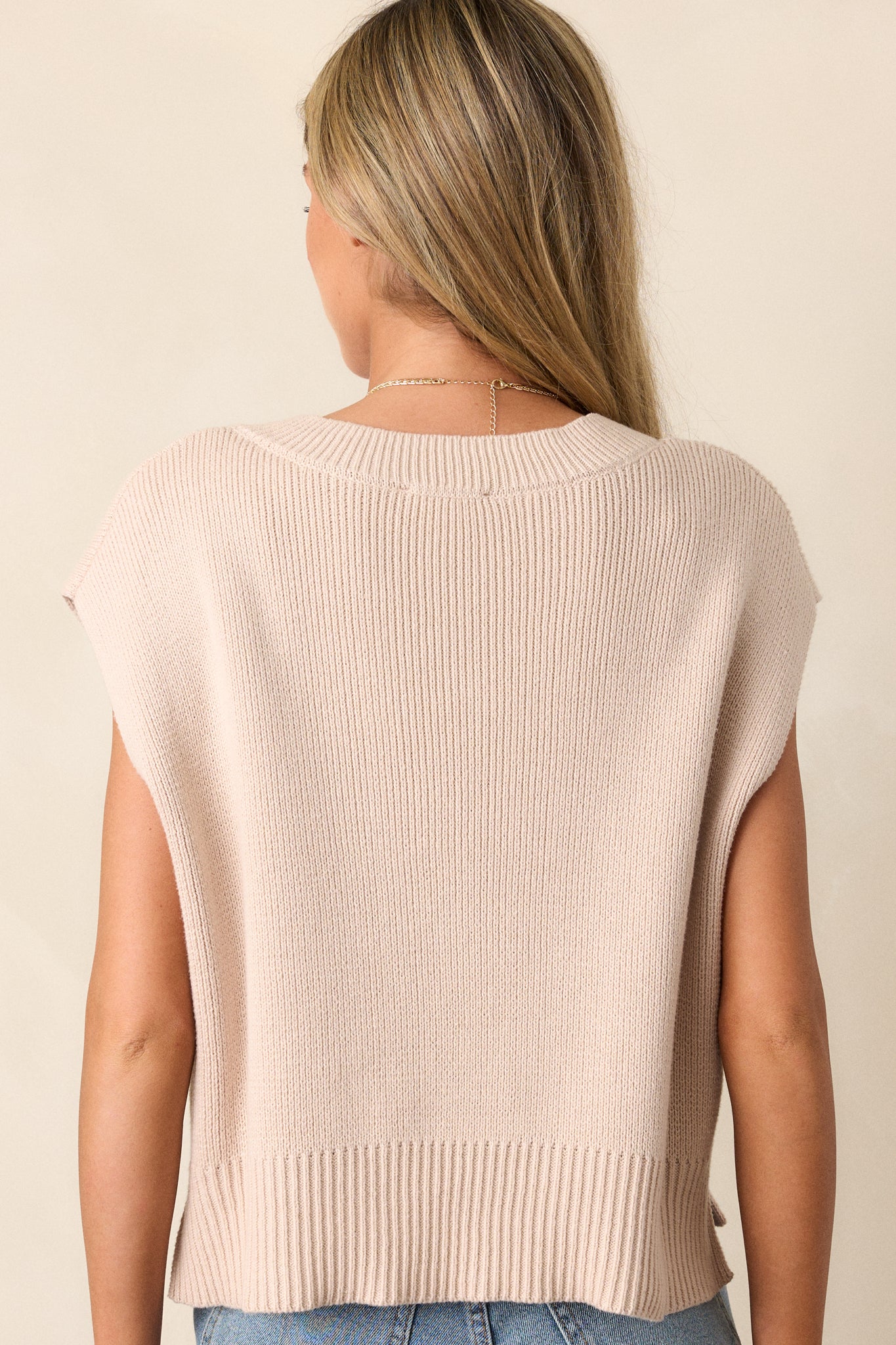 Back view of the beige sweater top, displaying the simplicity of the design, the clean lines, and the comfort of the relaxed fit.





