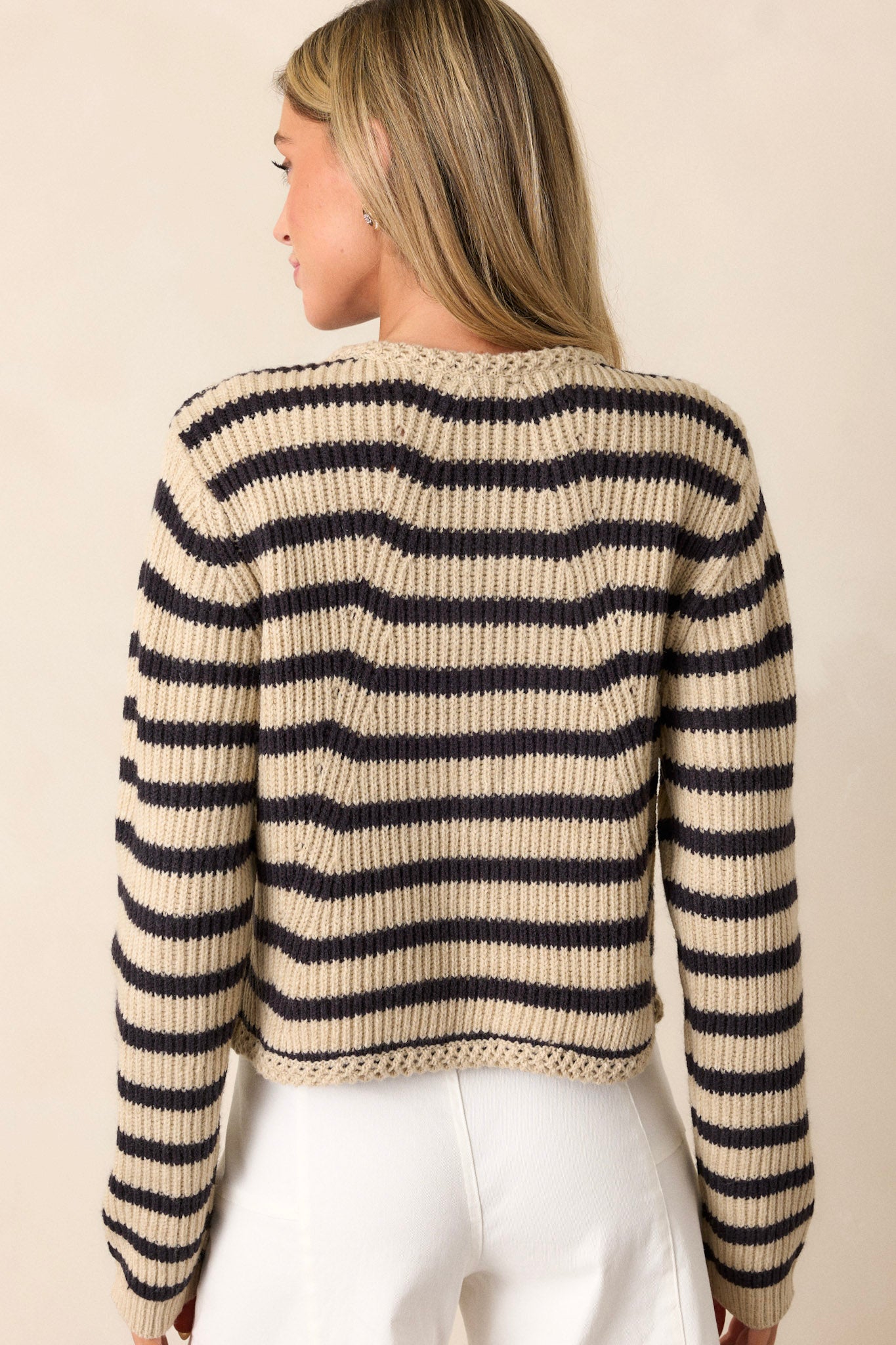 Back view of the tan cardigan, showcasing the black and tan stripe pattern and the continuation of the long-sleeved design.