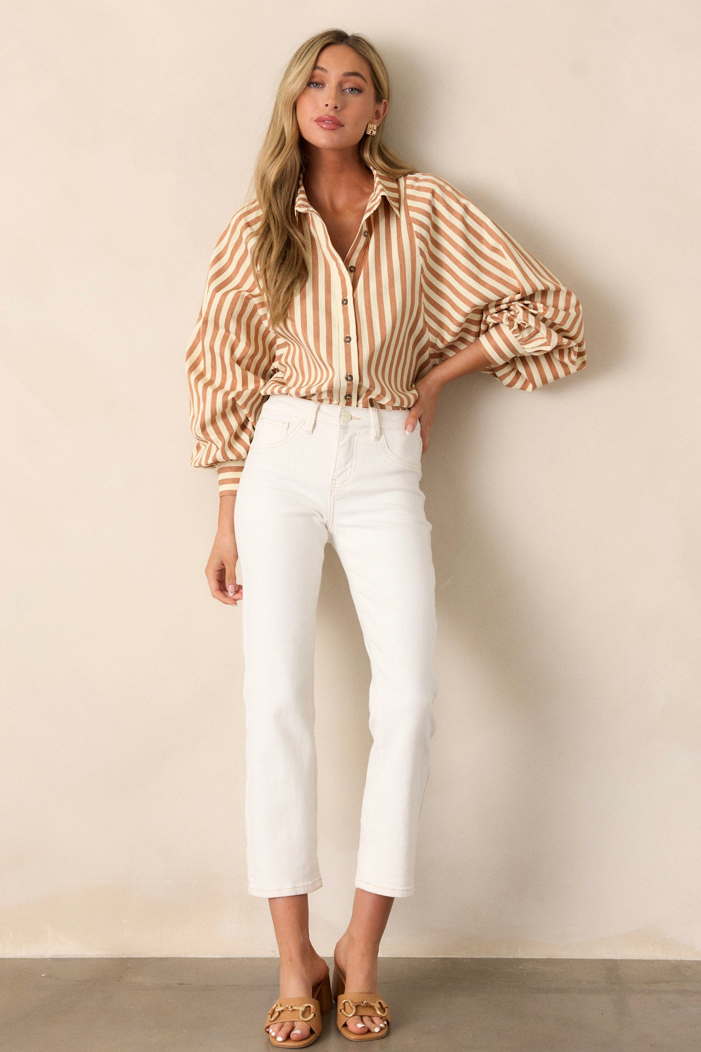 These white jeans feature a tan stitching, a front button and functional zipper, and two functional back pockets.