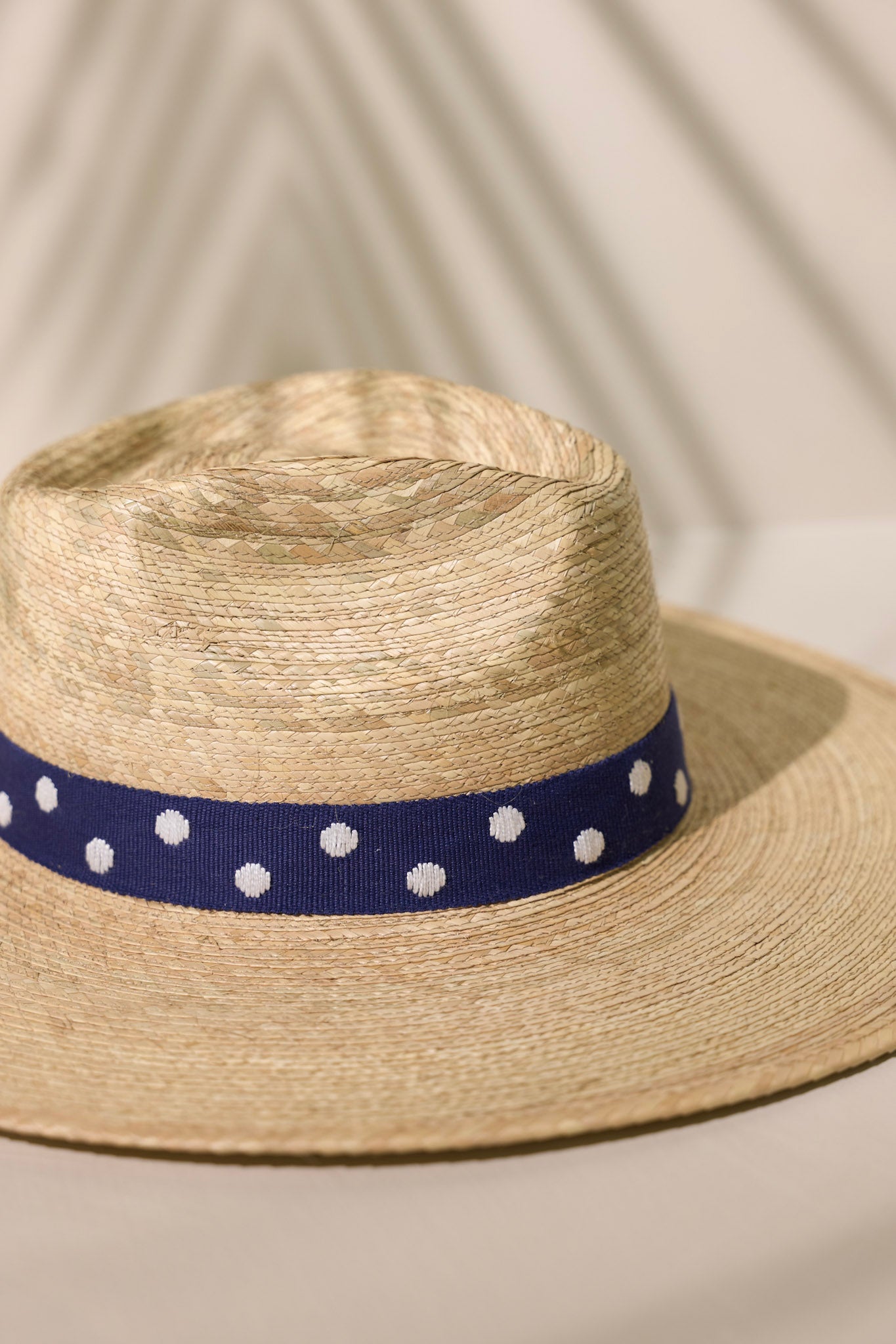Detailed shot of this Wendy hat features a navy, cotton woven band with white polka dots.