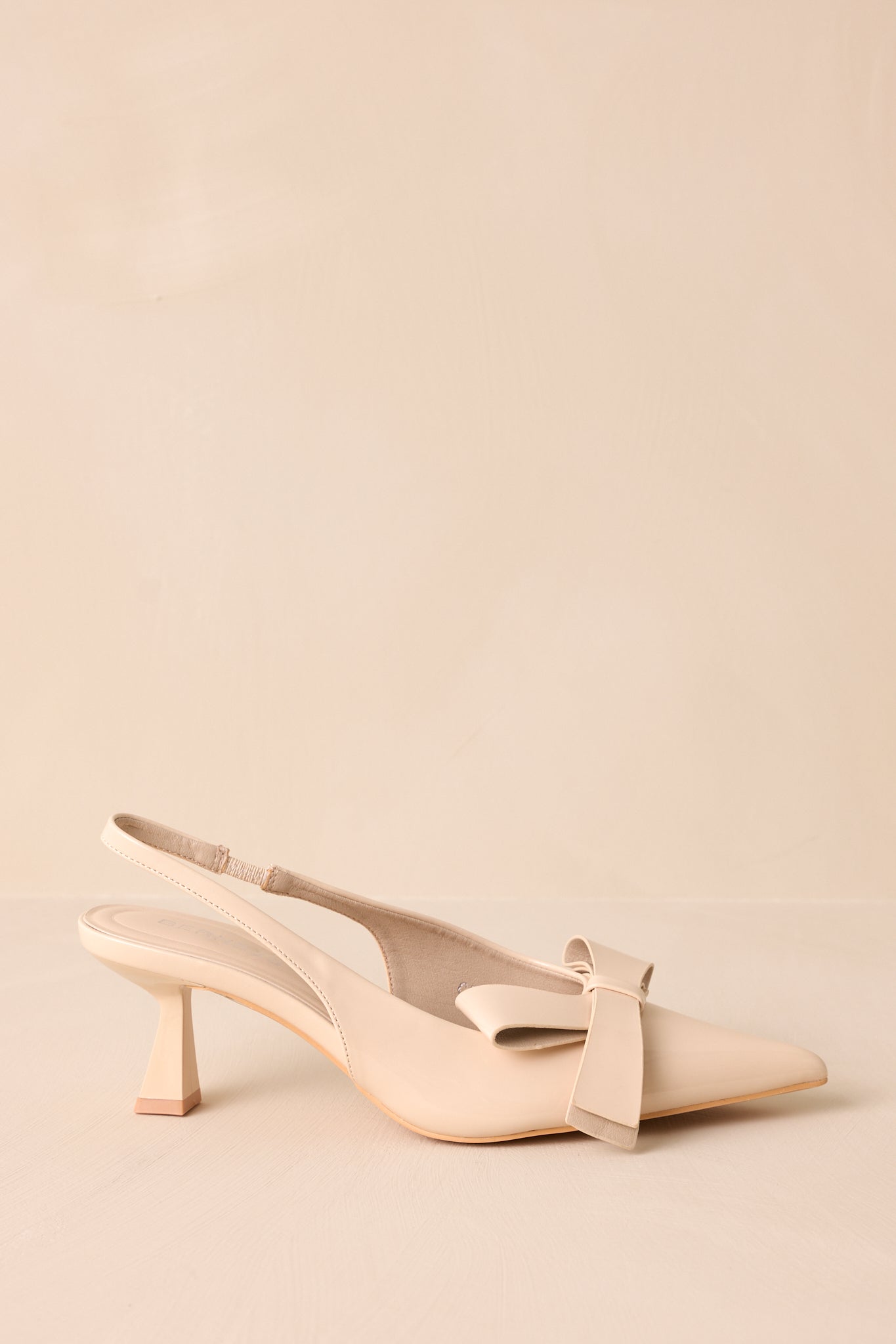 A side view of the ivory heels, emphasizing the slingback strap that adds a chic touch while ensuring a secure fit.