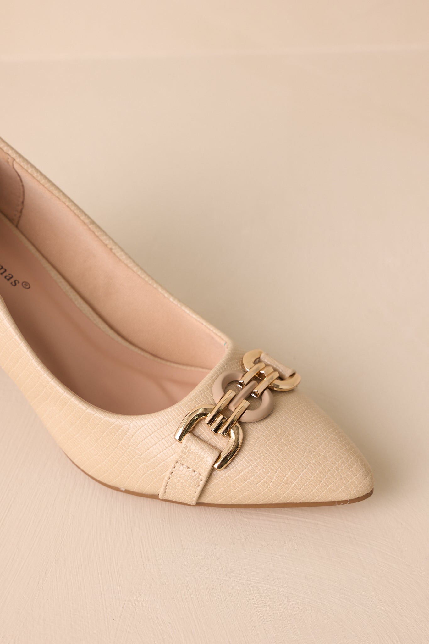 Close-up view of these heels that feature a crocodile pattern, chunky heel and gold buckle hardware on the pointed toe.