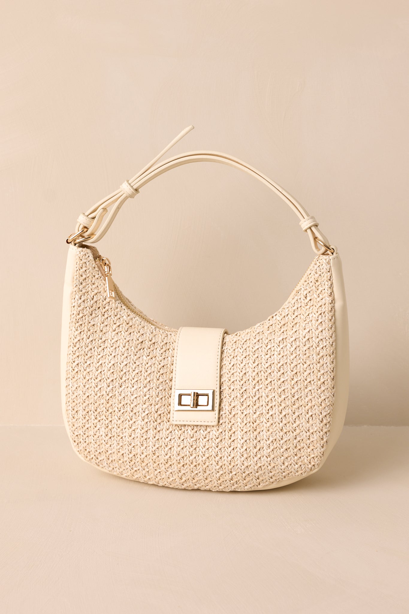 Full view of an ivory bag featuring an ivory shoulder strap, an optional crossbody chain strap, a top flap closure with a turn lock fastening, gold hardware, and a woven texture.