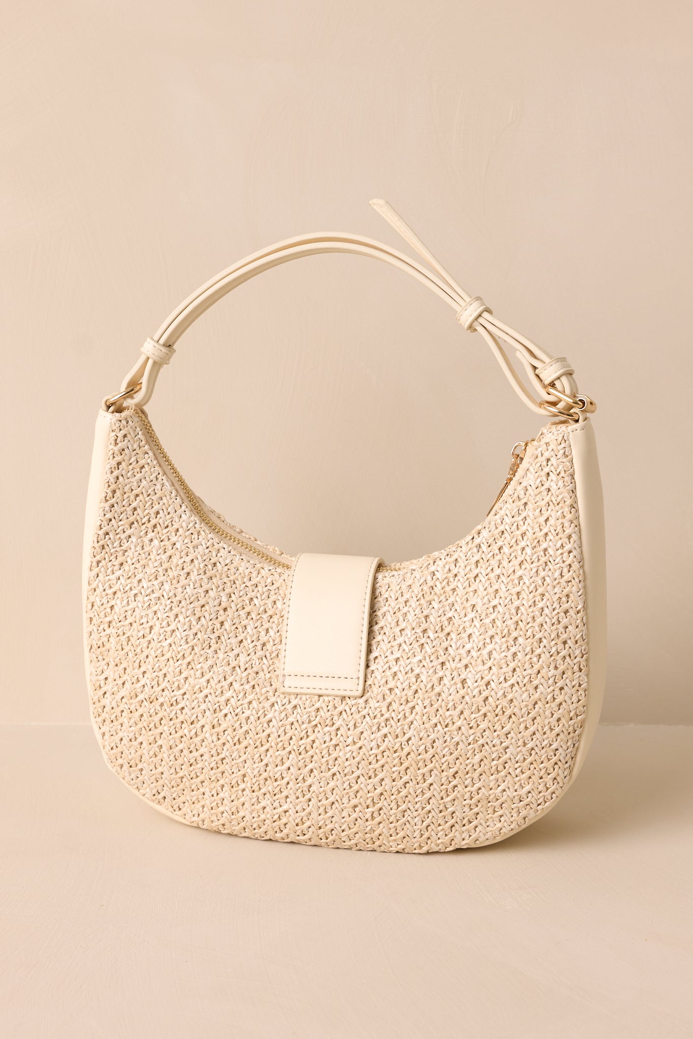 Back view of an ivory bag featuring an ivory shoulder strap, an optional crossbody chain strap, a top flap closure with a turn lock fastening, gold hardware, and a woven texture.