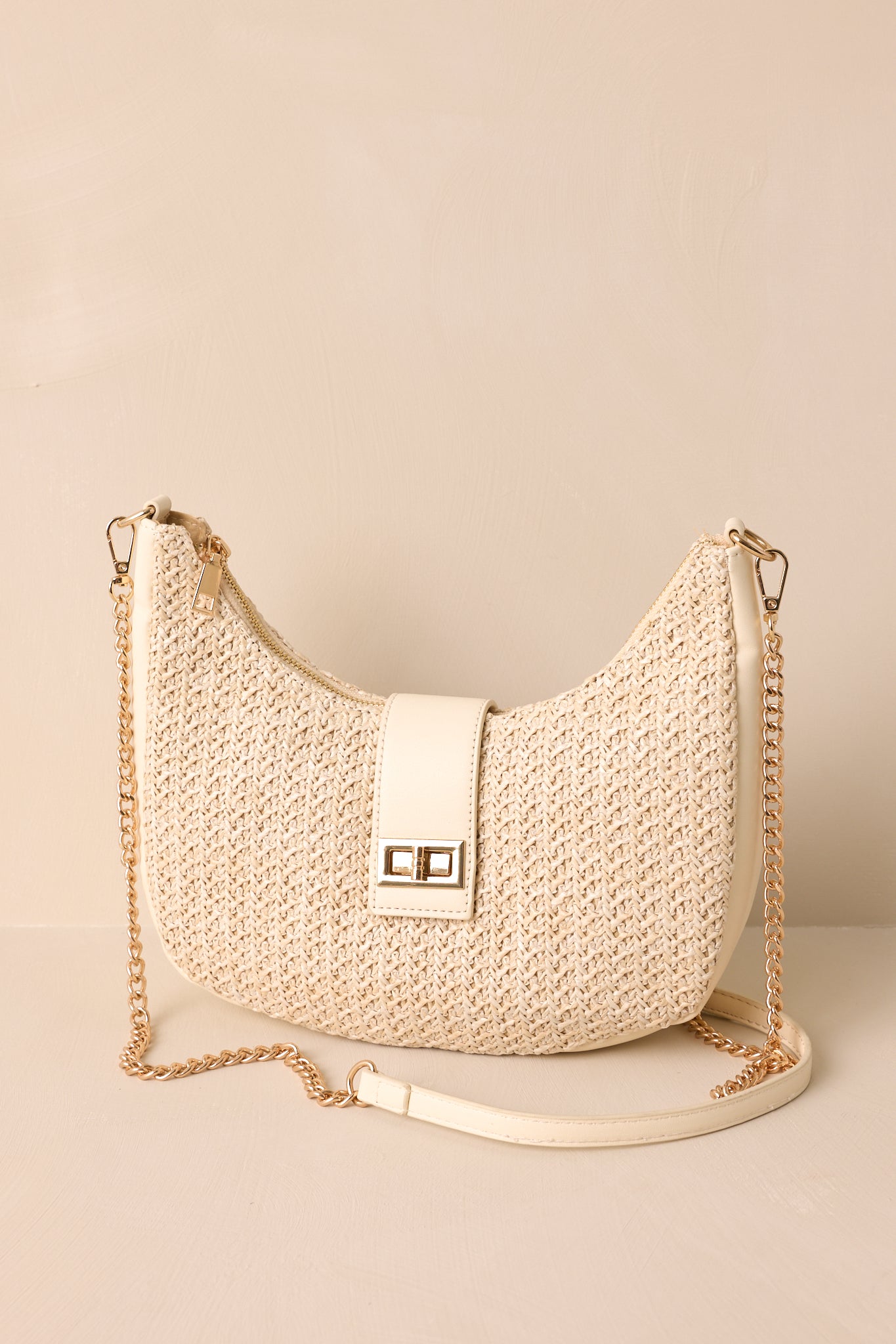 Full view showcasing the optional crossbody chain strap on this woven ivory handbag. 