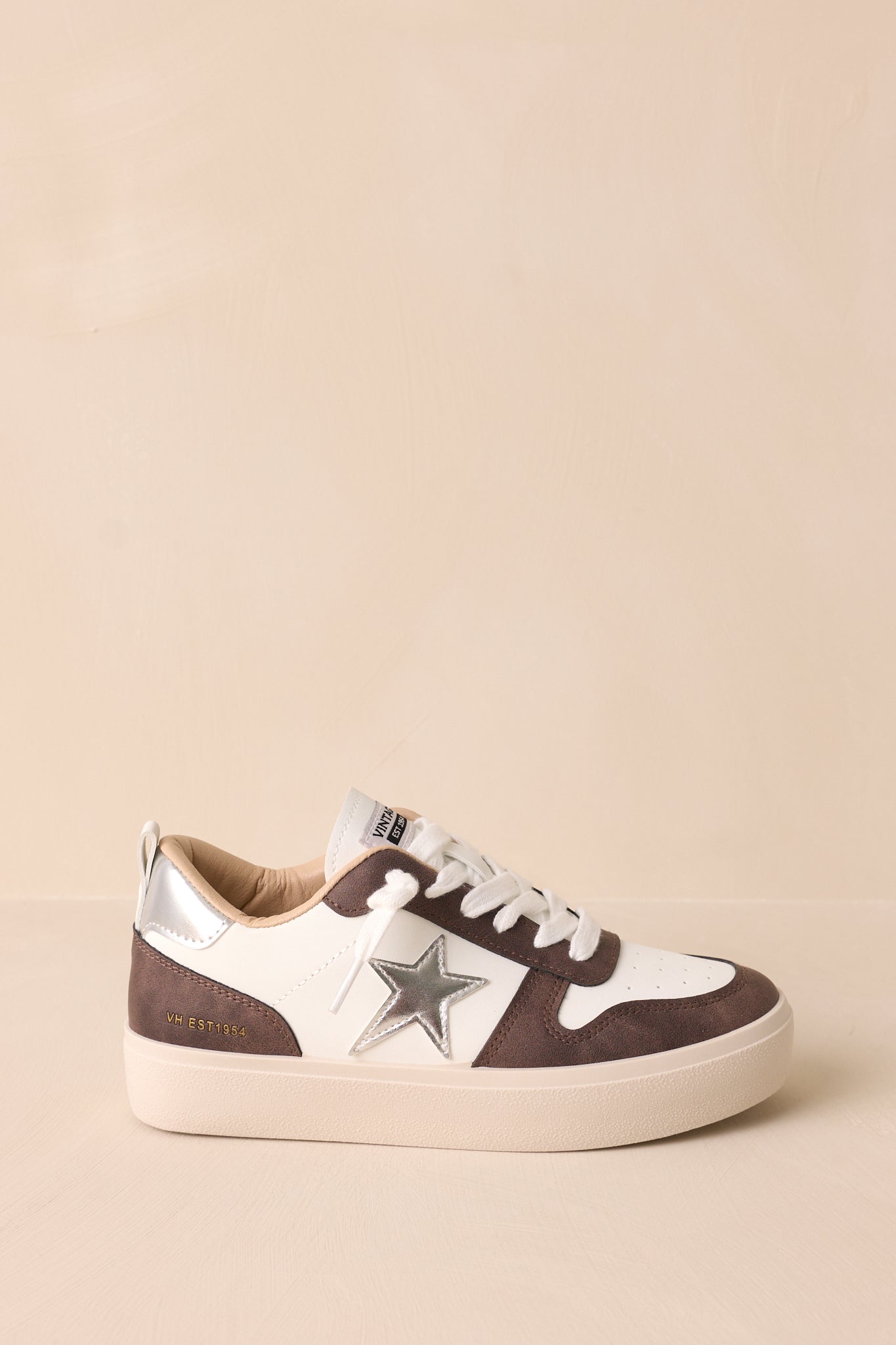 Side view of the brown sneaker, showcasing the rounded toe and the unique silver star detailing.