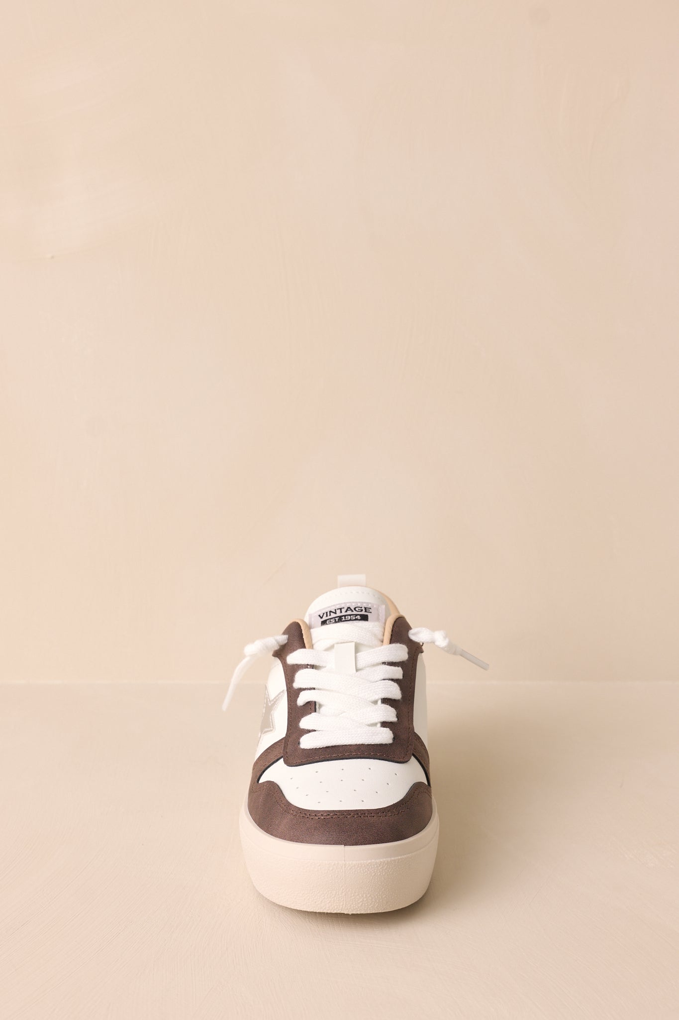 Front view of the brown sneaker, emphasizing the functional white laces and interchangeable brown laces