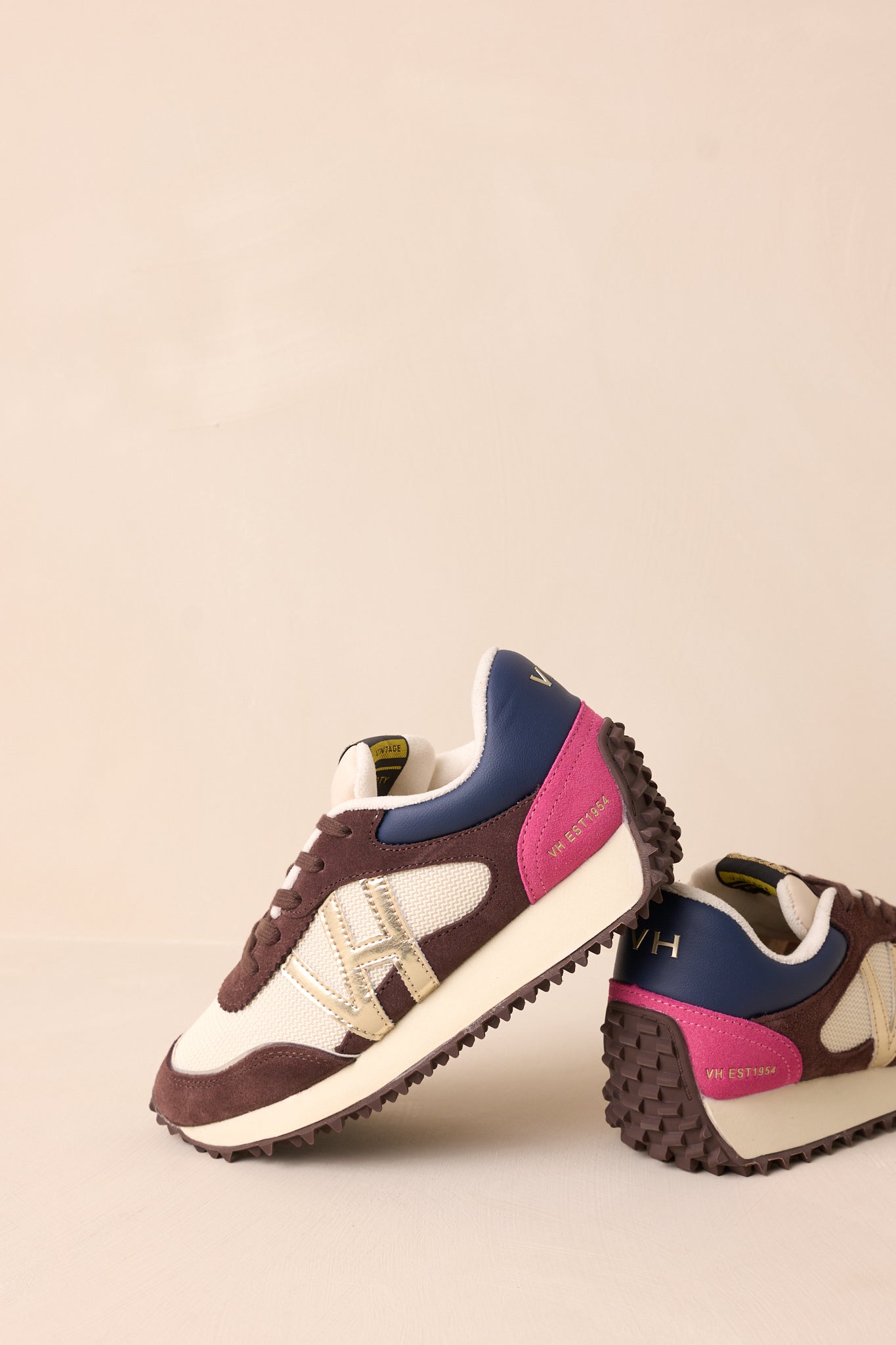 A zoomed-in angle on the gold detailing along the side of the chocolate sneakers, paired with the textured faux leather material and subtle pink accents.