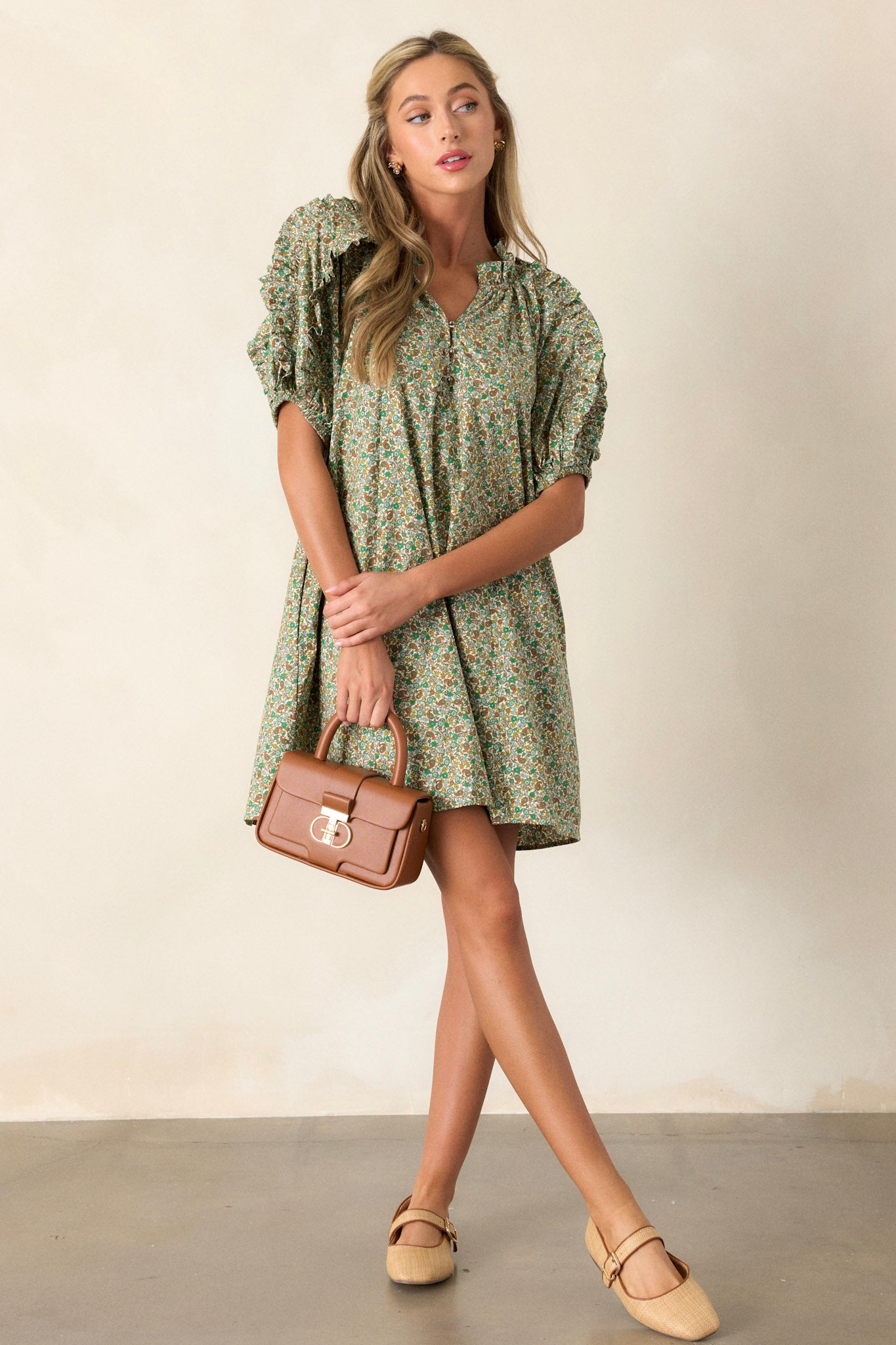 This playful and unique green dress features flouncy bubble sleeves, a small v-neck, fun frills, and two functional side pockets.