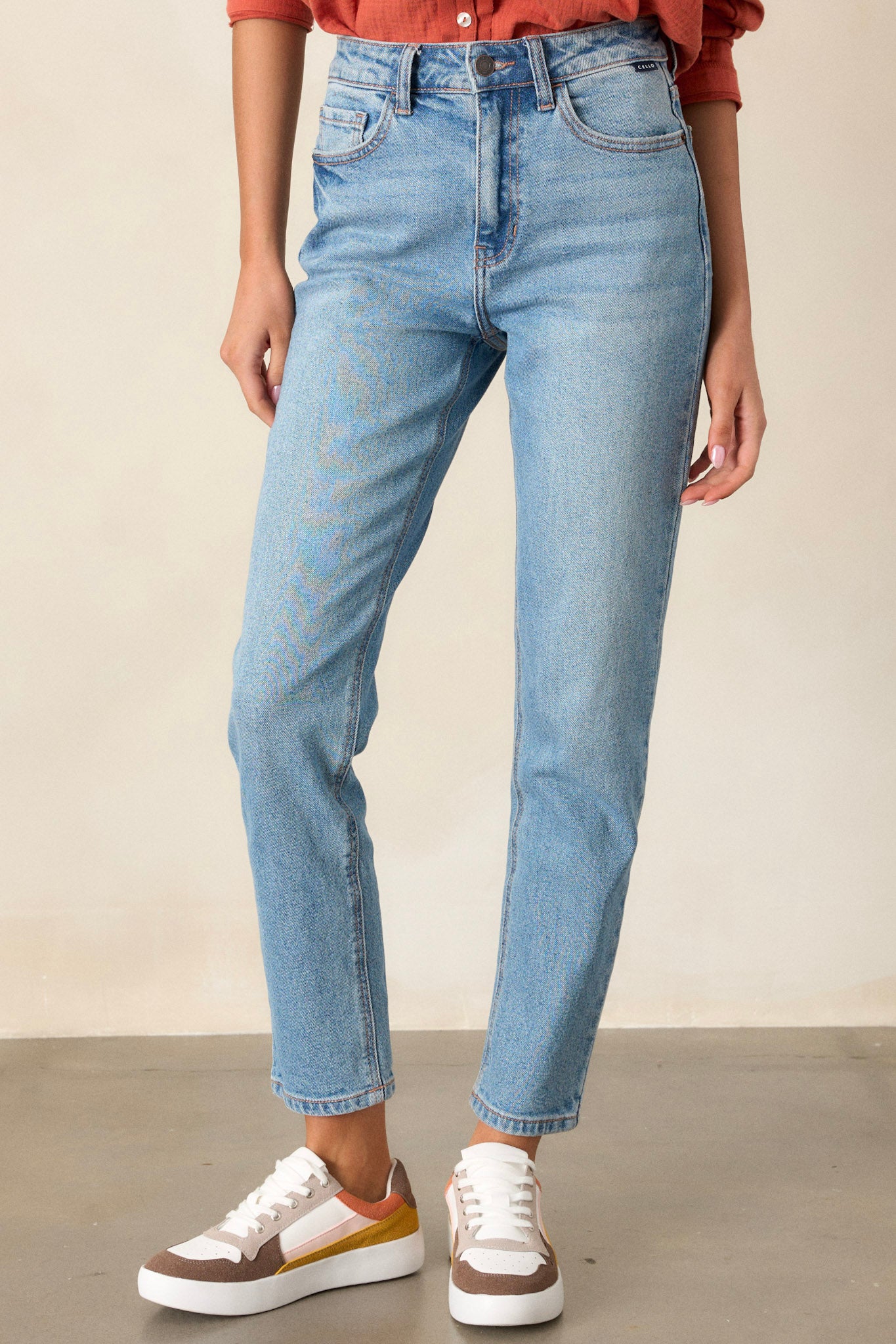 Front view of these medium wash straight leg jeans featuring 5-pocket detailing and a standard zipper and button closure.