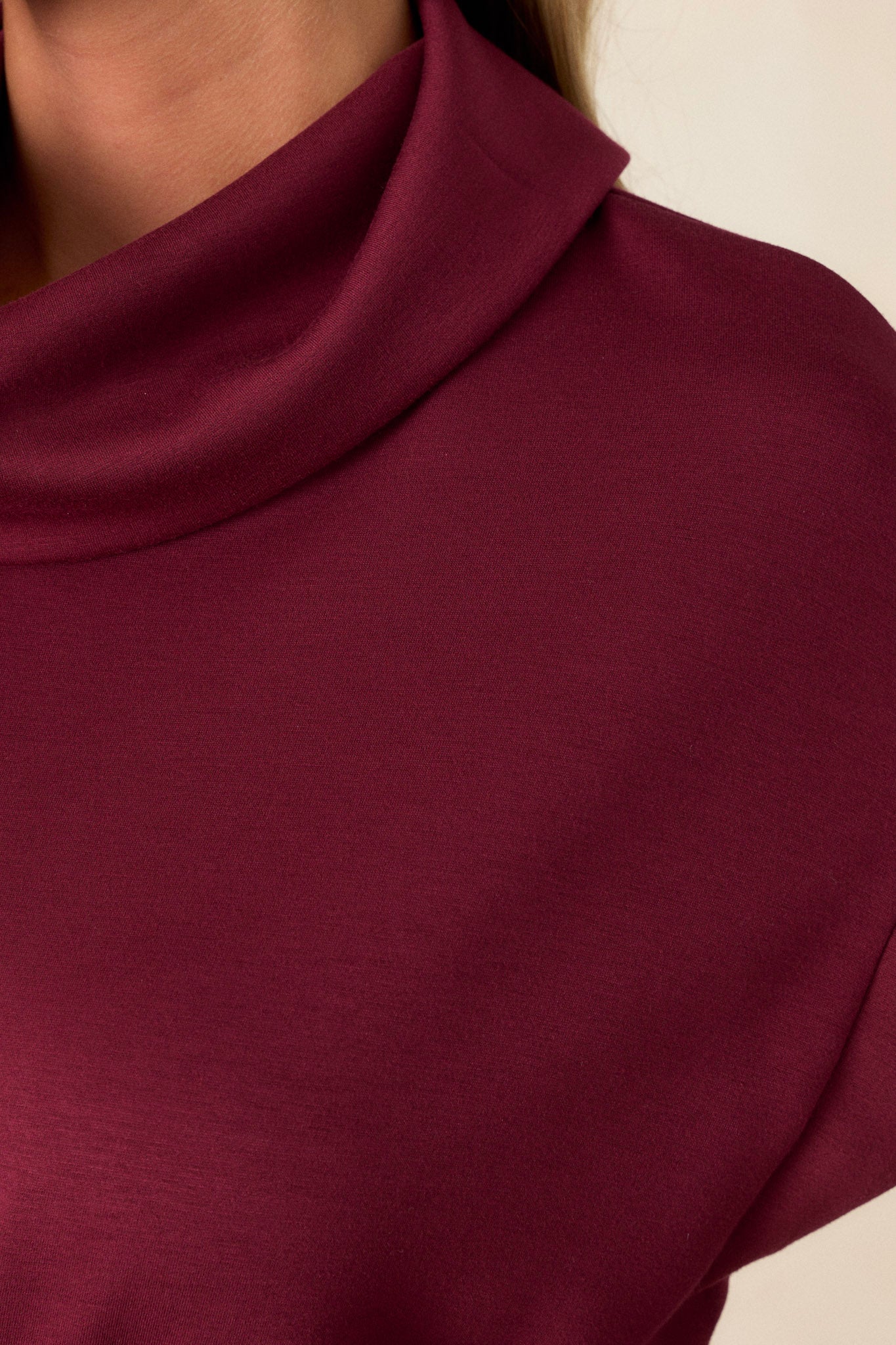 Close-up view of this burgundy dress with short sleeves, drawstring waist, cowl turtleneck, and pockets, perfect for any occasion.