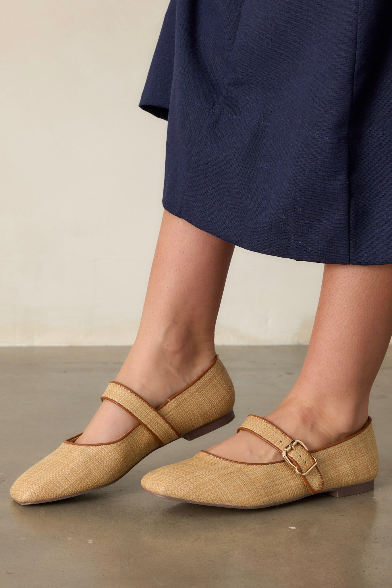 These natural flats feature a square toe, a buckle closure, and a brown detailing around edge.