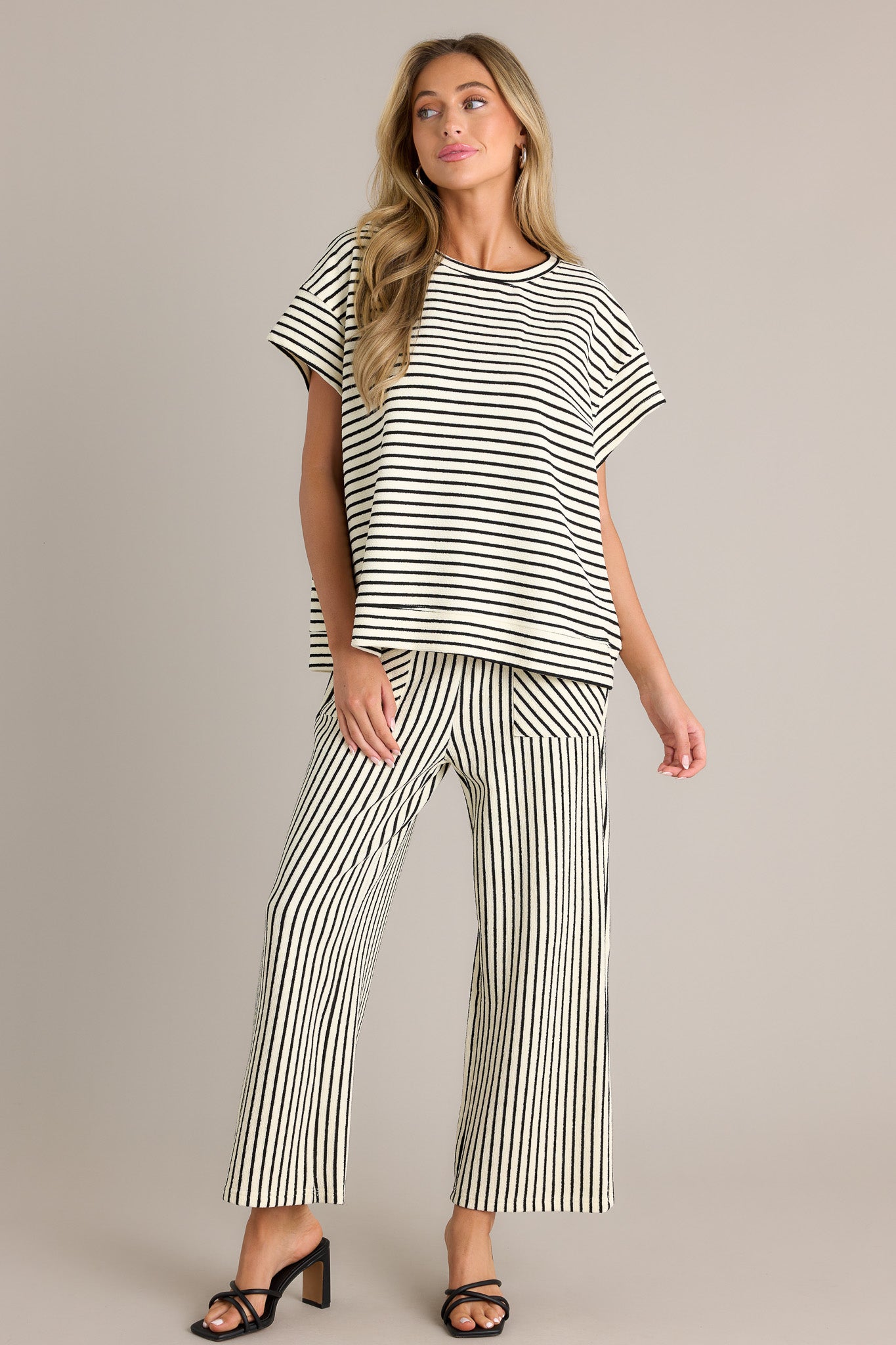 Full length view of a black stripe top with a crew neckline, a thick textured material, a thick hemline, and short sleeves