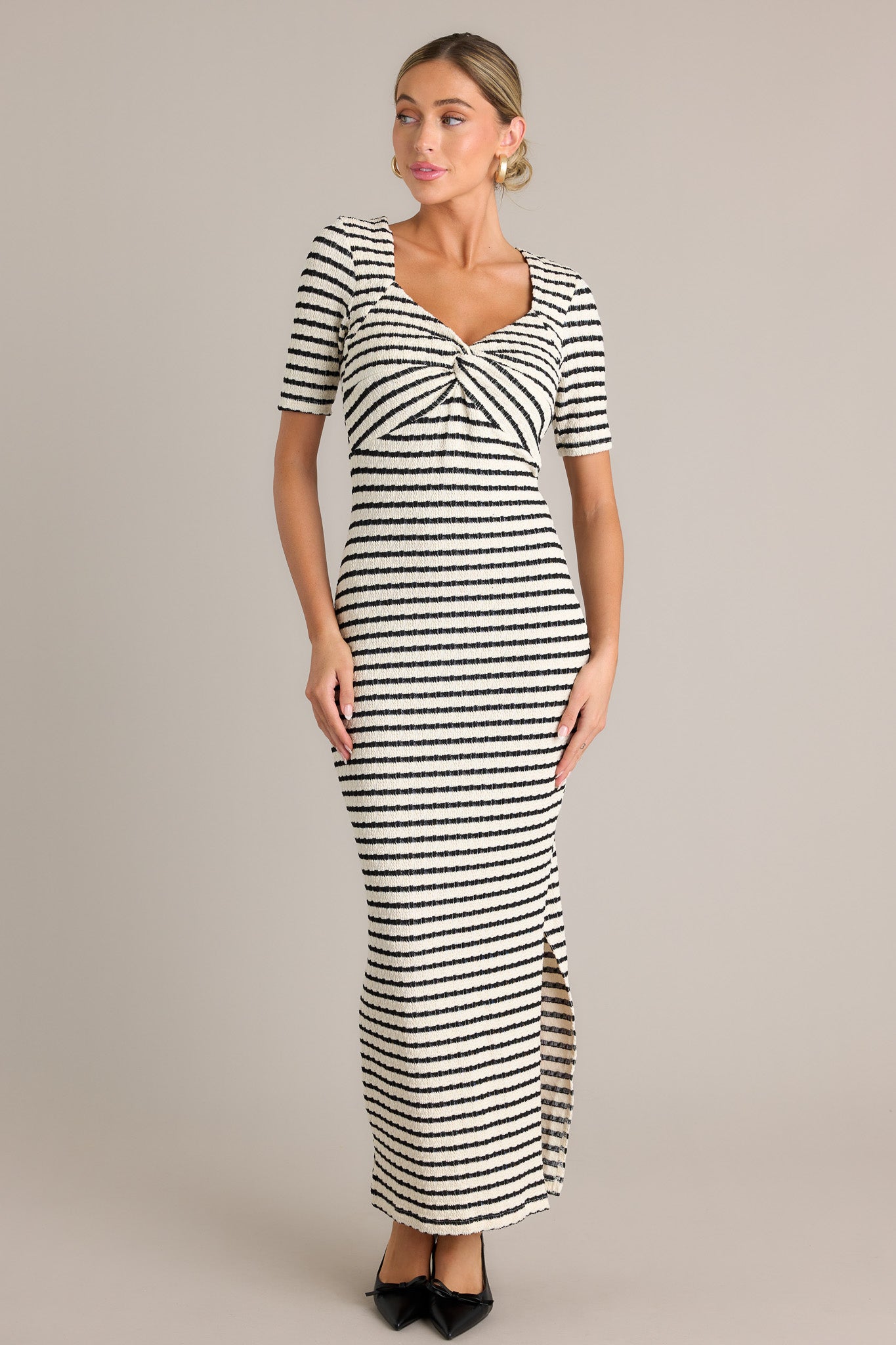 This black stripe maxi dress features a v-neckline, a twisted bust detail, a bodycon fit, a textured fabric, a side slit, and short sleeves.