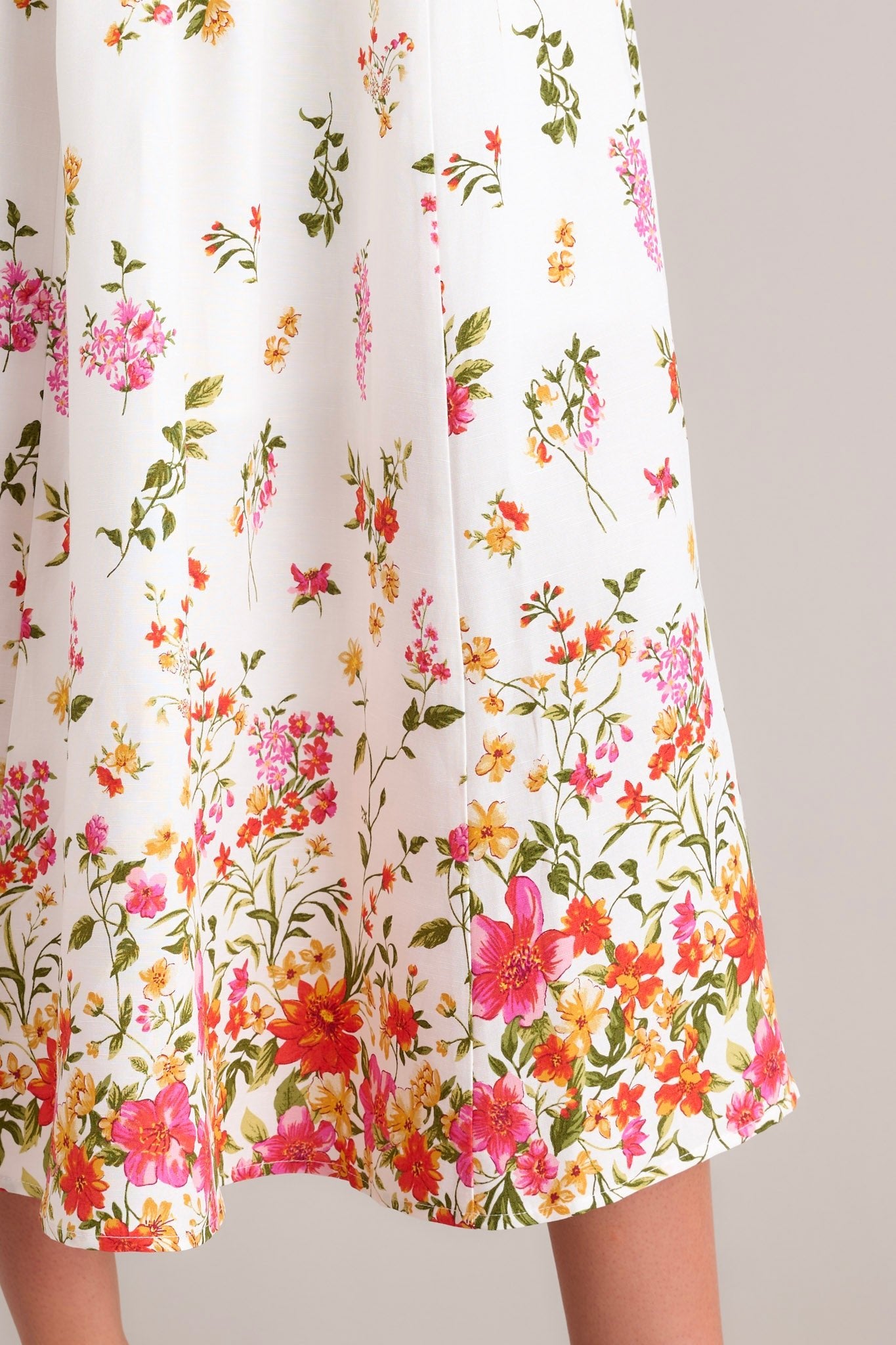 A detailed close-up of this ivory midi dress with a colorful botanical print, highlighting the intricate floral designs and the lightweight fabric.