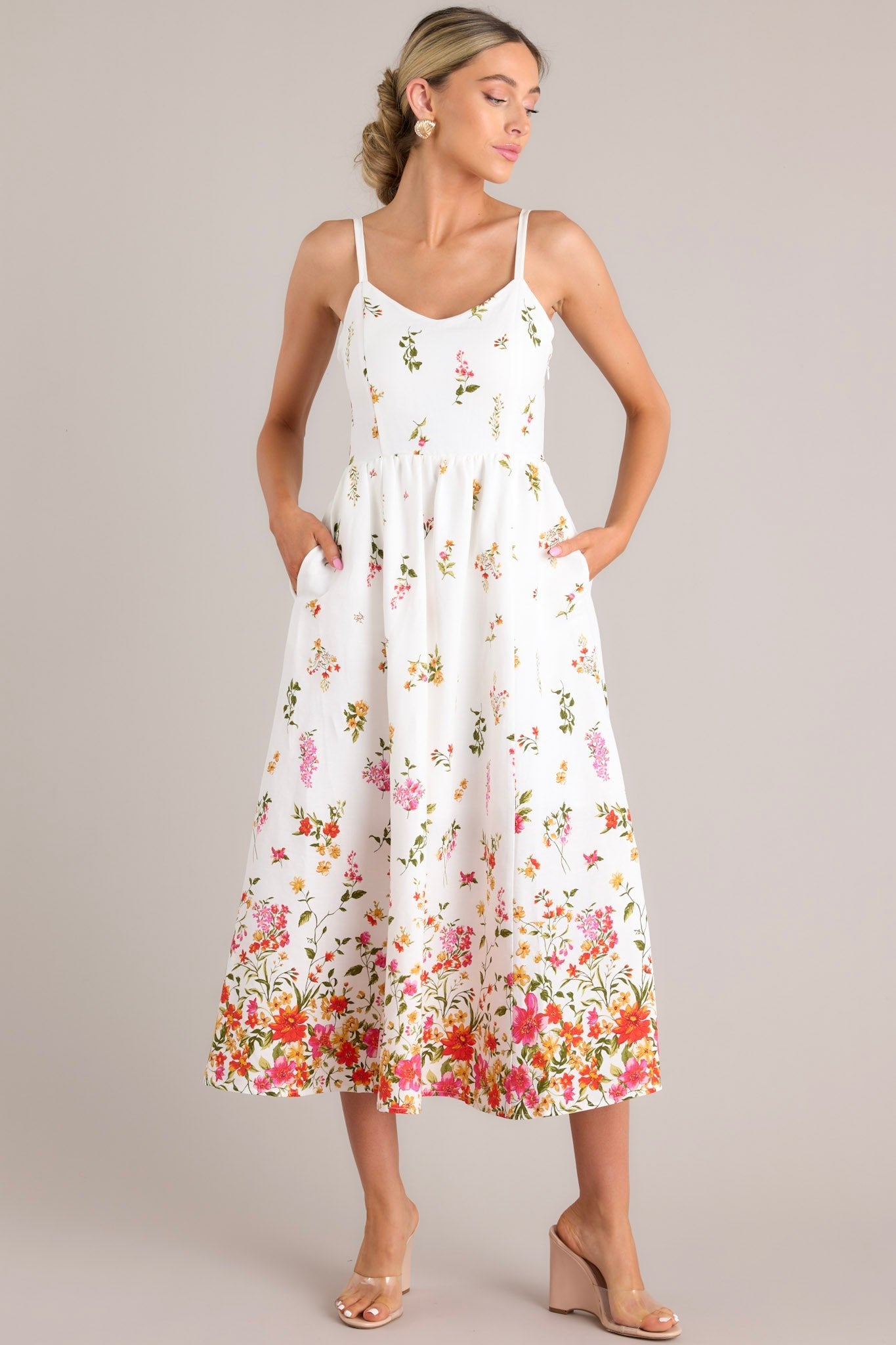 This Ivory midi dress features a colorful floral print, a fitted bodice, and a flared skirt.