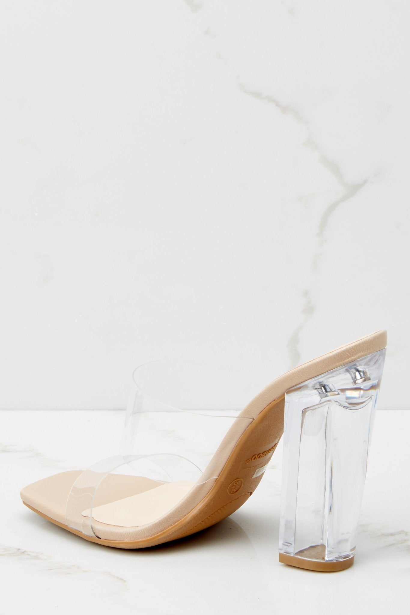 A back view of the heels, focusing on the clear block heel and the minimalistic design of the straps from behind.