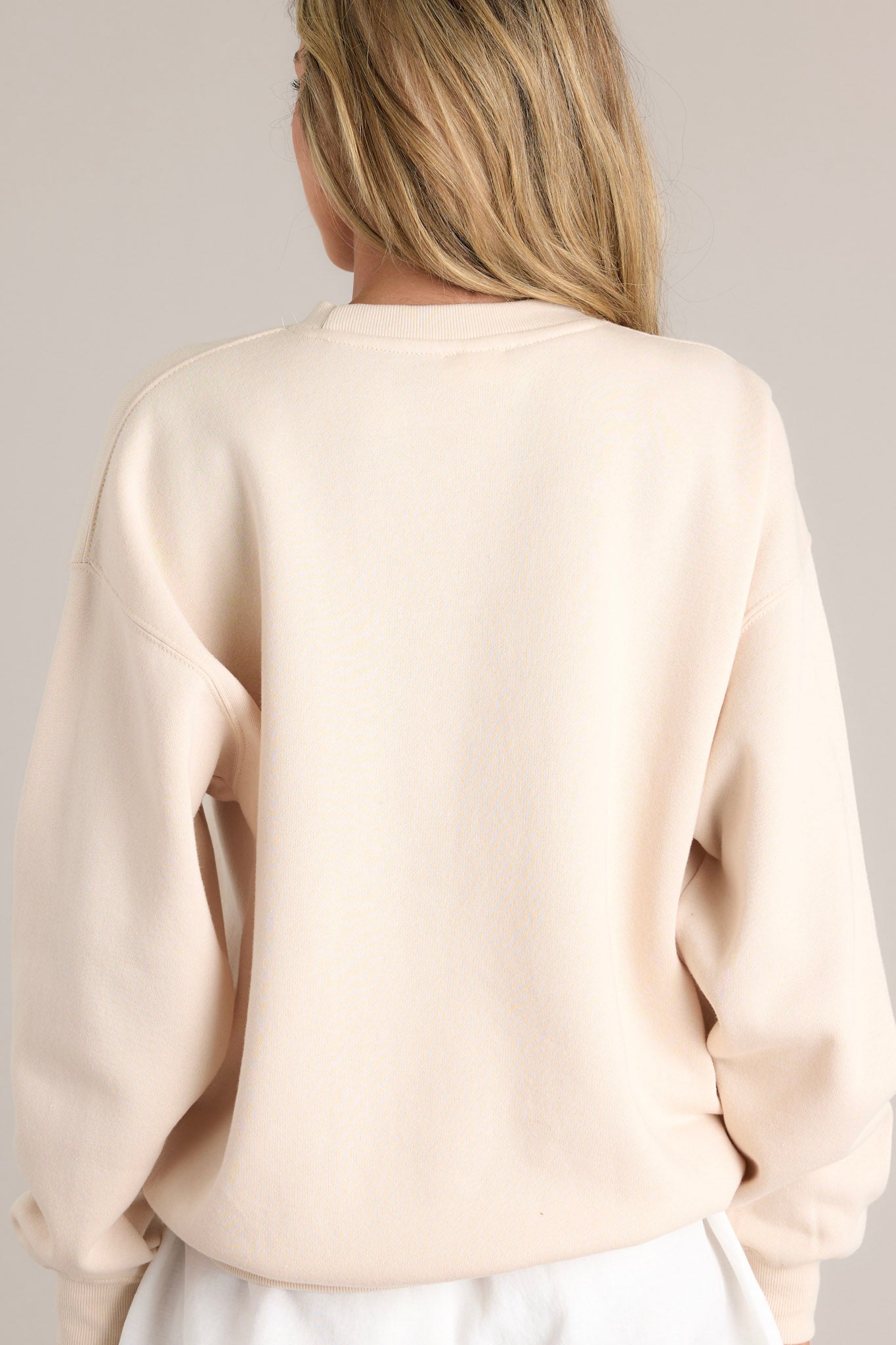 Back view of this natural embroidered sweatshirt that features "Los Angeles" across the bust, a crew neckline, and ribbed hems.