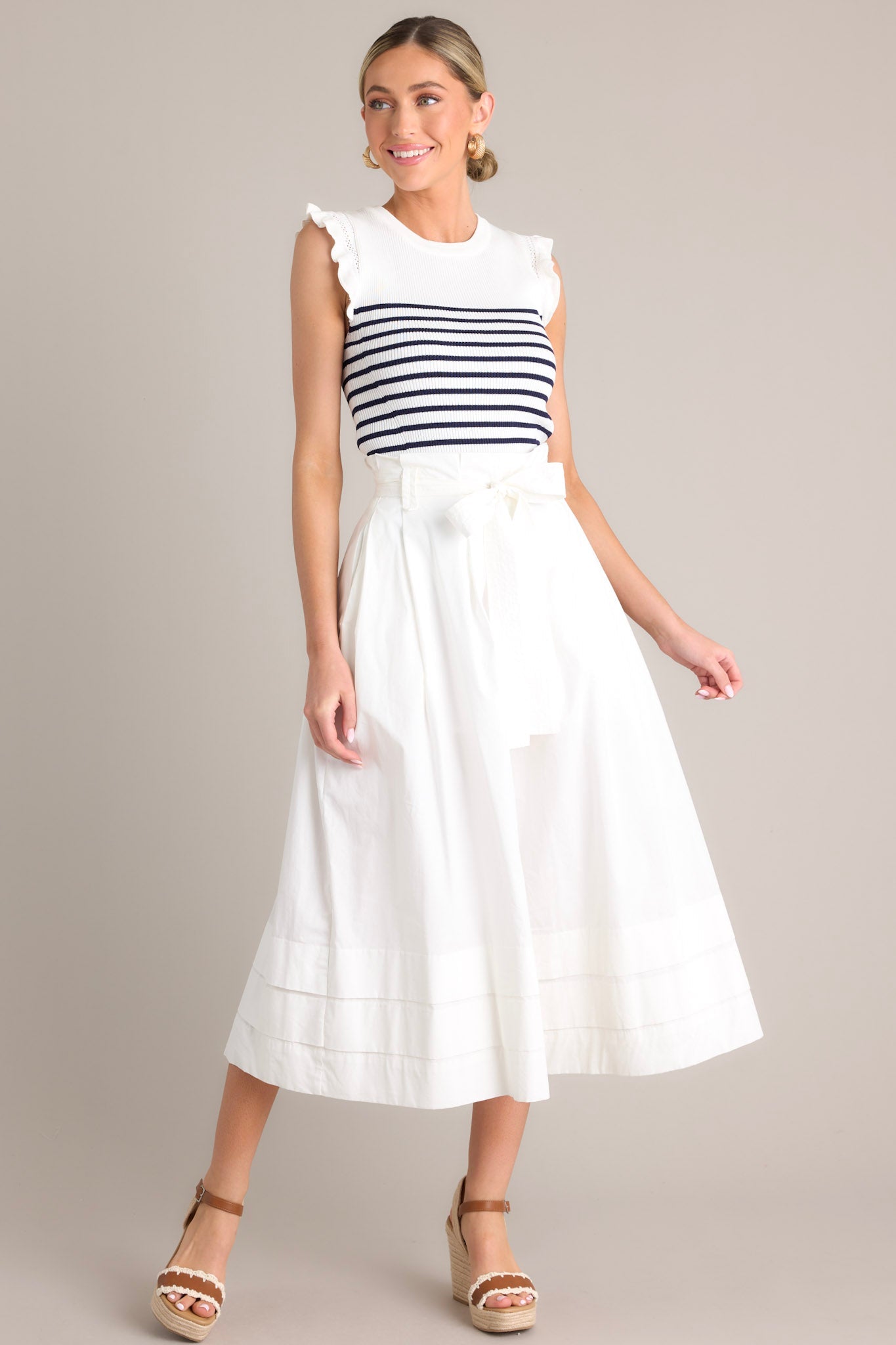This white & navy striped top features a ribbed crew neckline, horizontal stripes, a stretchy knit fabric, and flutter sleeves.