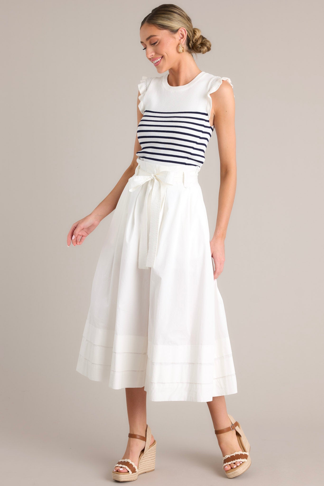 Full length view of a white & navy striped top with a ribbed crew neckline, horizontal stripes, stretchy knit fabric, and flutter sleeves