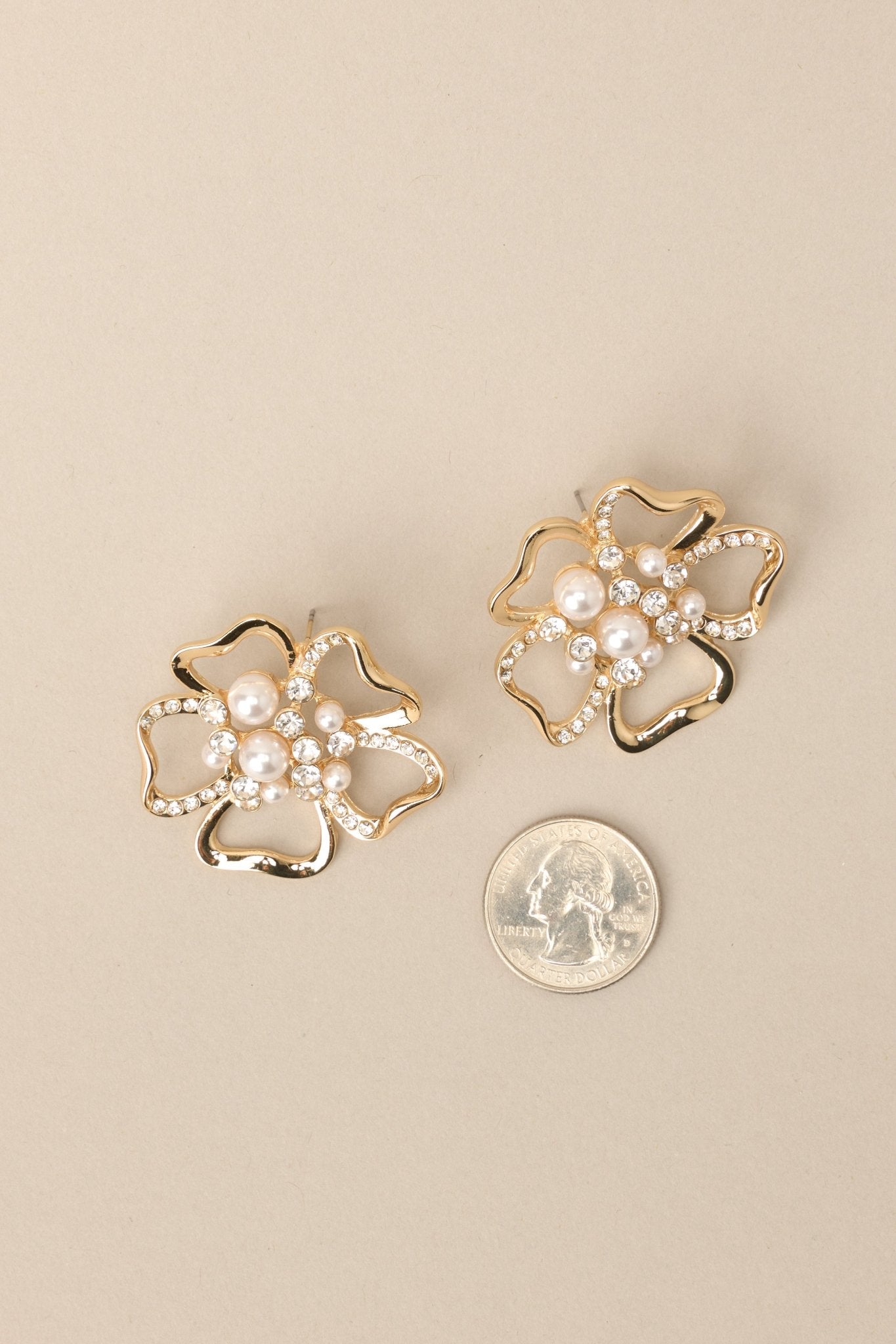 A quarter next to these flower shape earrings to compare the size.  