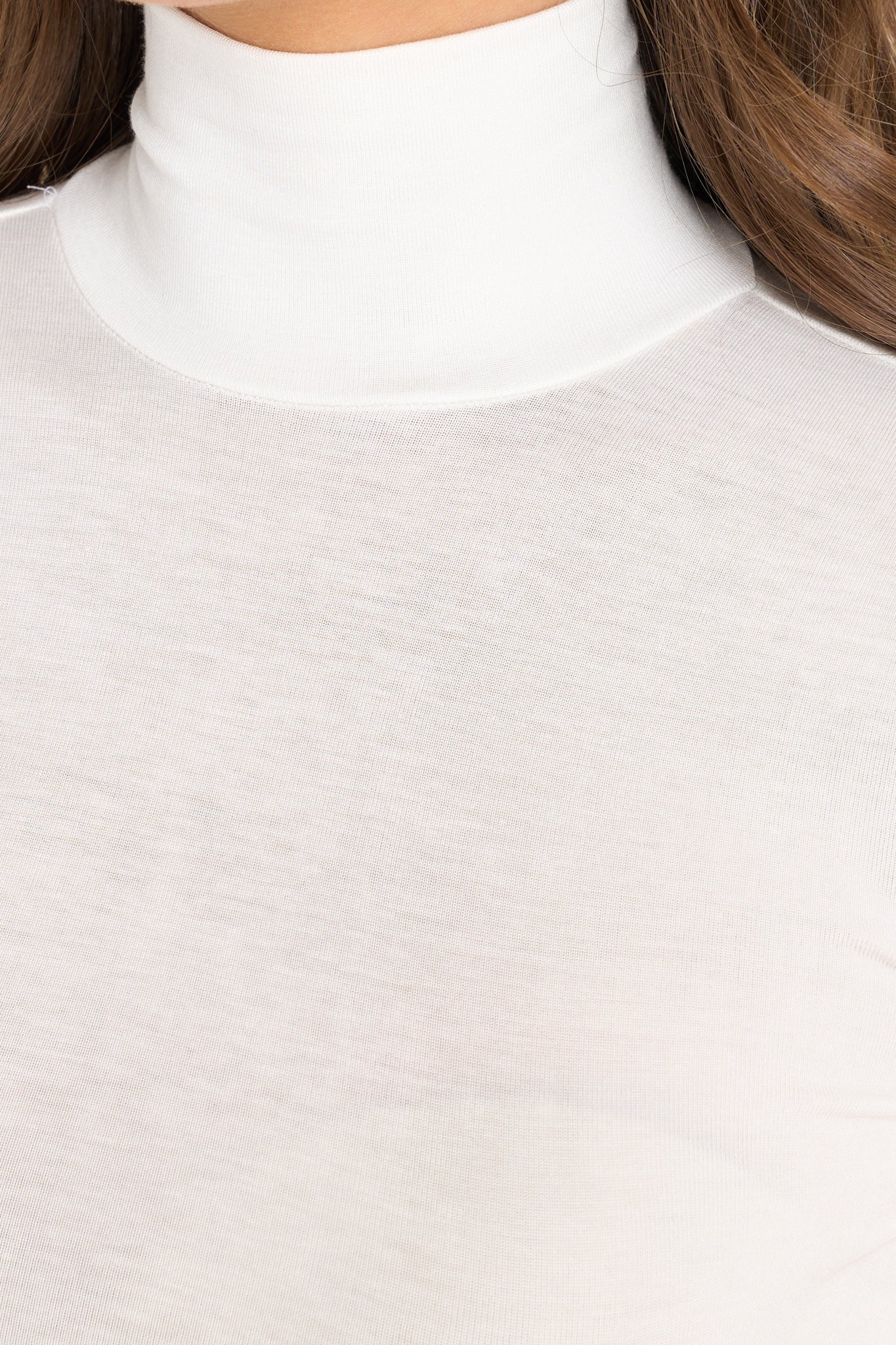 Close up view of this top that features a turtleneck design, long sleeves with slits at the cuffs, and a soft, stretchy material throughout.