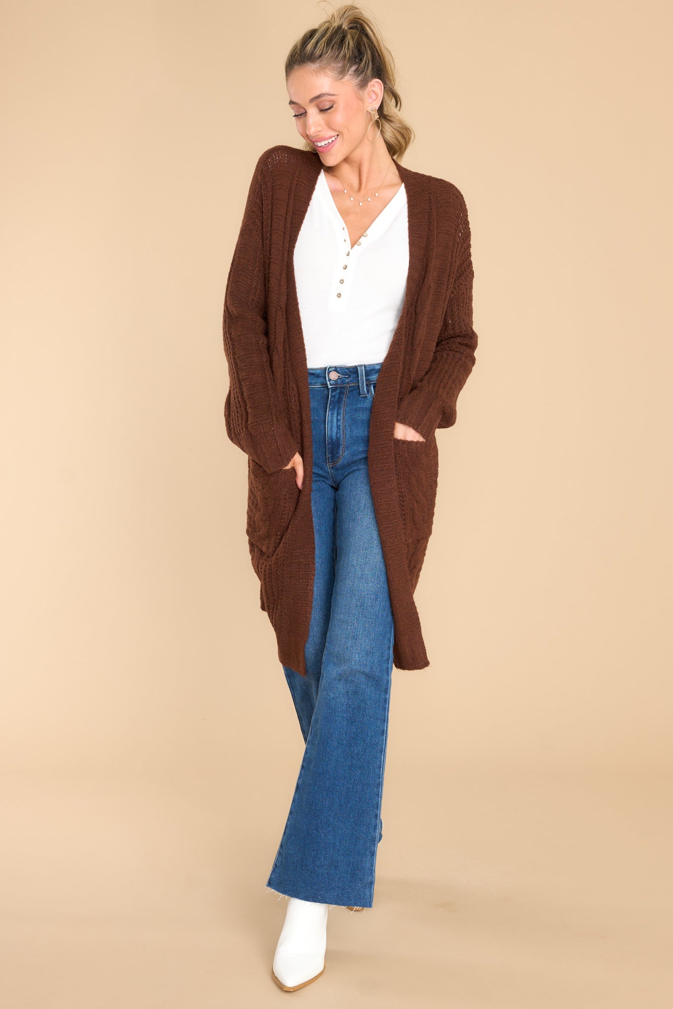 This all brown cardigan features an open-front design, long sleeves with tapered cuffs, functional pockets, and a soft knit feel throughout.