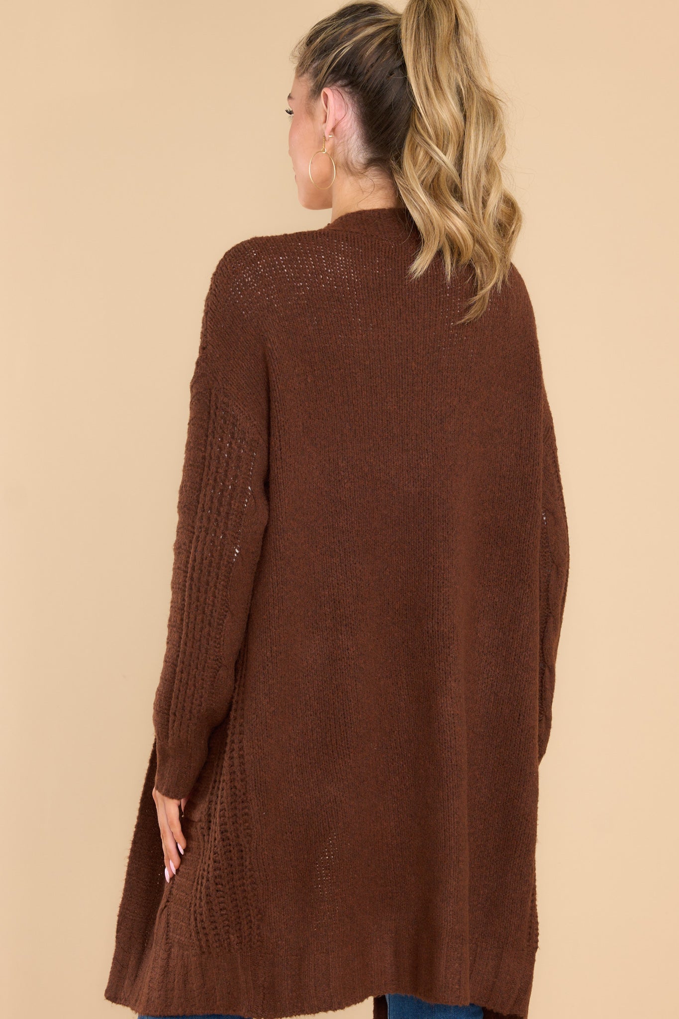 Back view of this cardigan that features an open-front design, long sleeves with tapered cuffs, functional pockets, and a soft knit feel throughout.