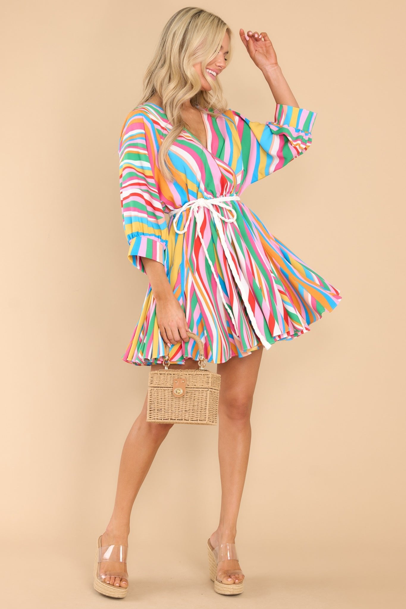 This multi-colored dress features a v-neckline, large dolman sleeves, elastic waistband, a removable self-tie around the waist, and a flowy skirt.