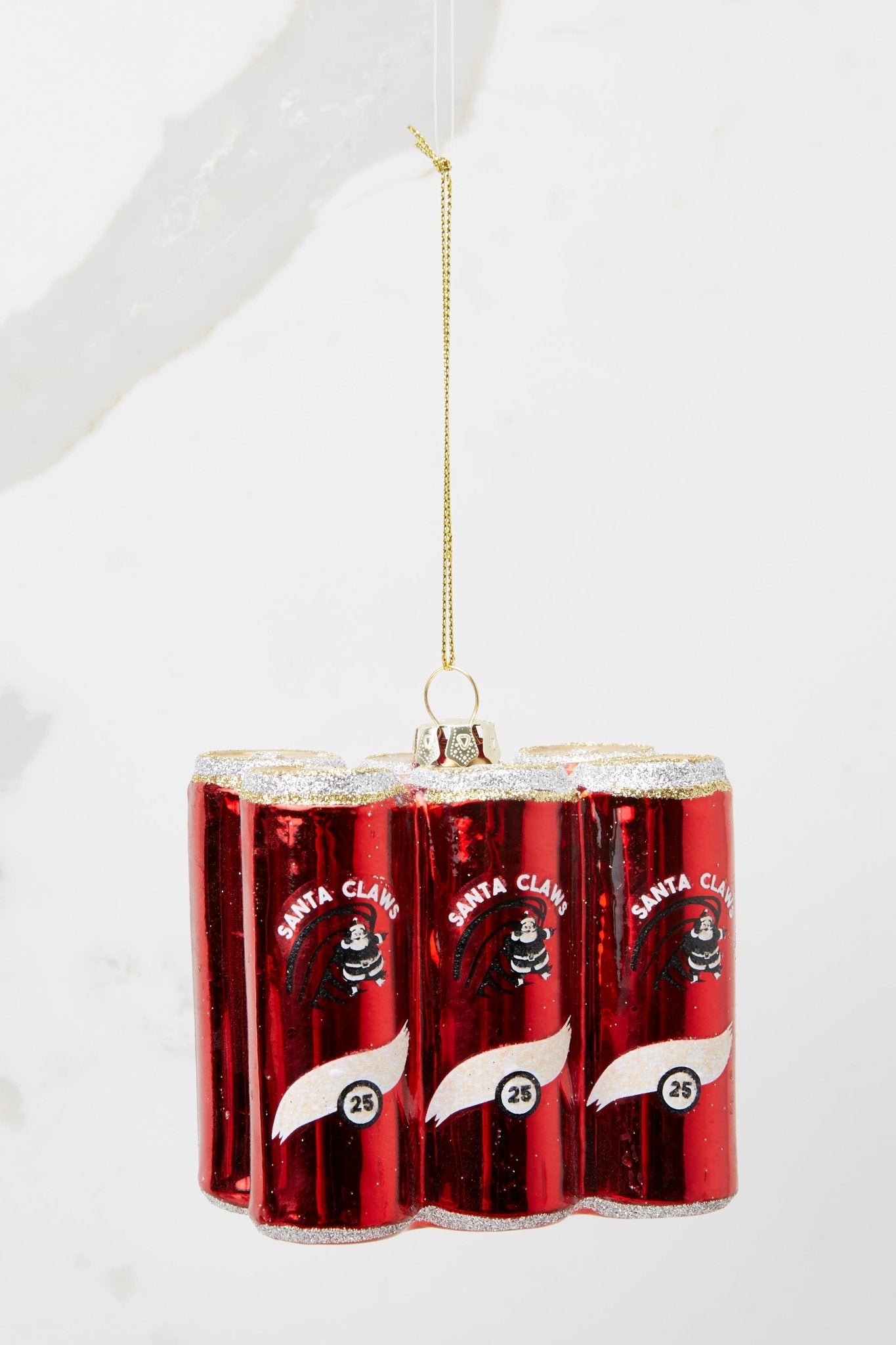 This red ornament features six red cans with white and gold accents and glitter detailing.