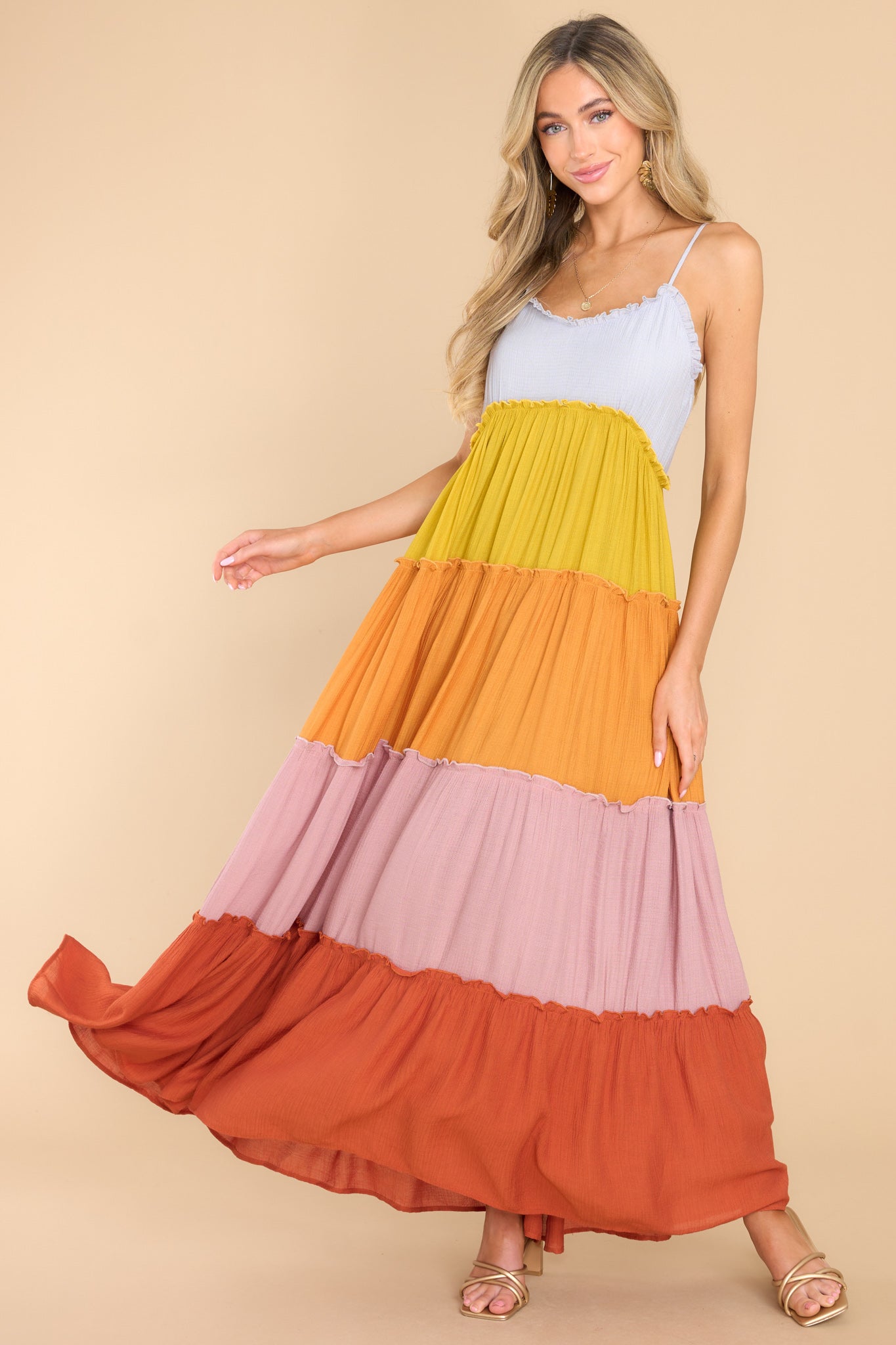 This multi-colored dress features a sweetheart neckline with ruffle detailing, thin adjustable shoulder straps, functional buttons for closure in the back of the bust, and a multicolored, tiered skirt with ruffle detailing. 