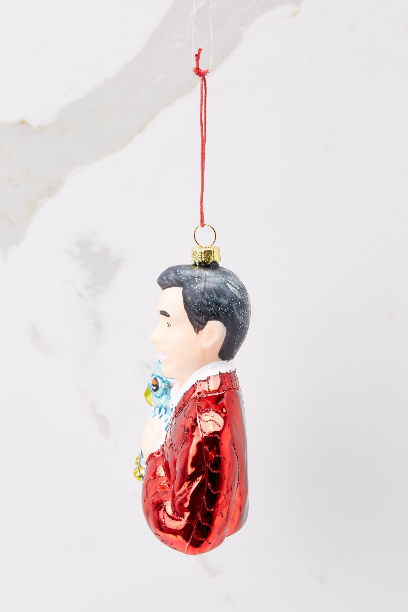 Side view of this ornament that features a design of Mister Rogers with hand painted glitter detailing.