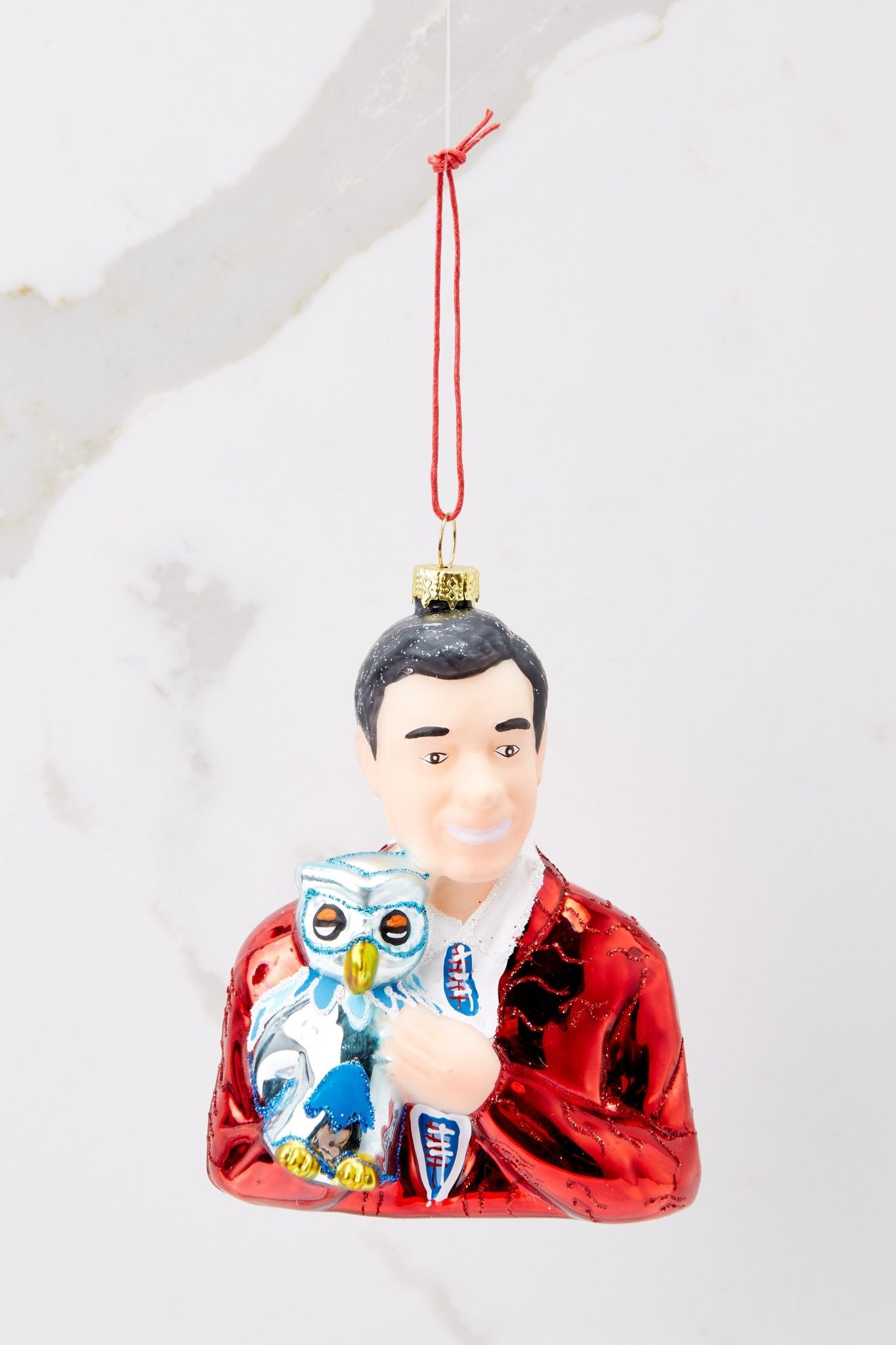 This red ornament features a design of Mister Rogers with hand painted glitter detailing.