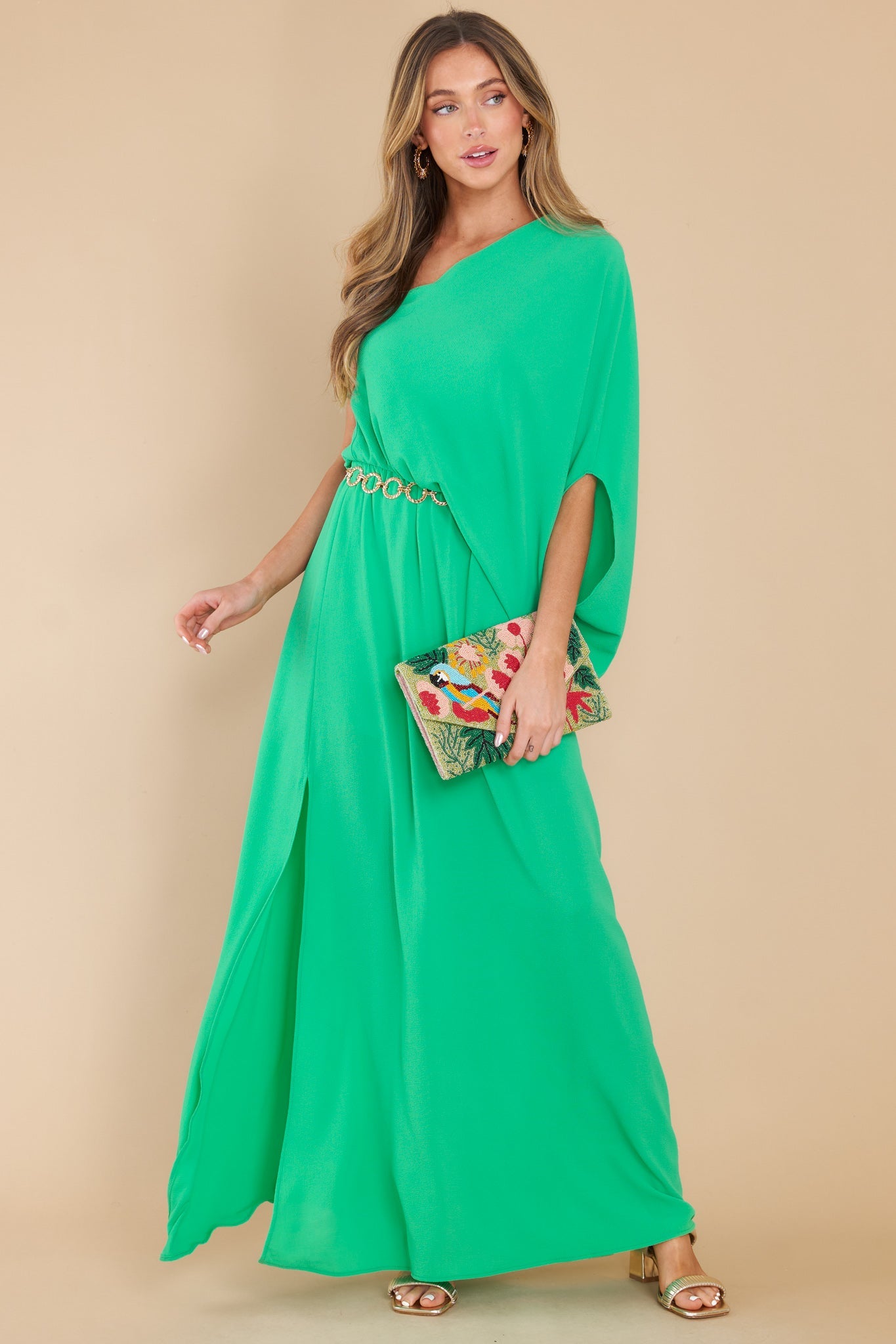 Full body view of this dress that features an off the shoulder neckline, large dolman sleeve, an elastic waistline, and an elegant side slit.