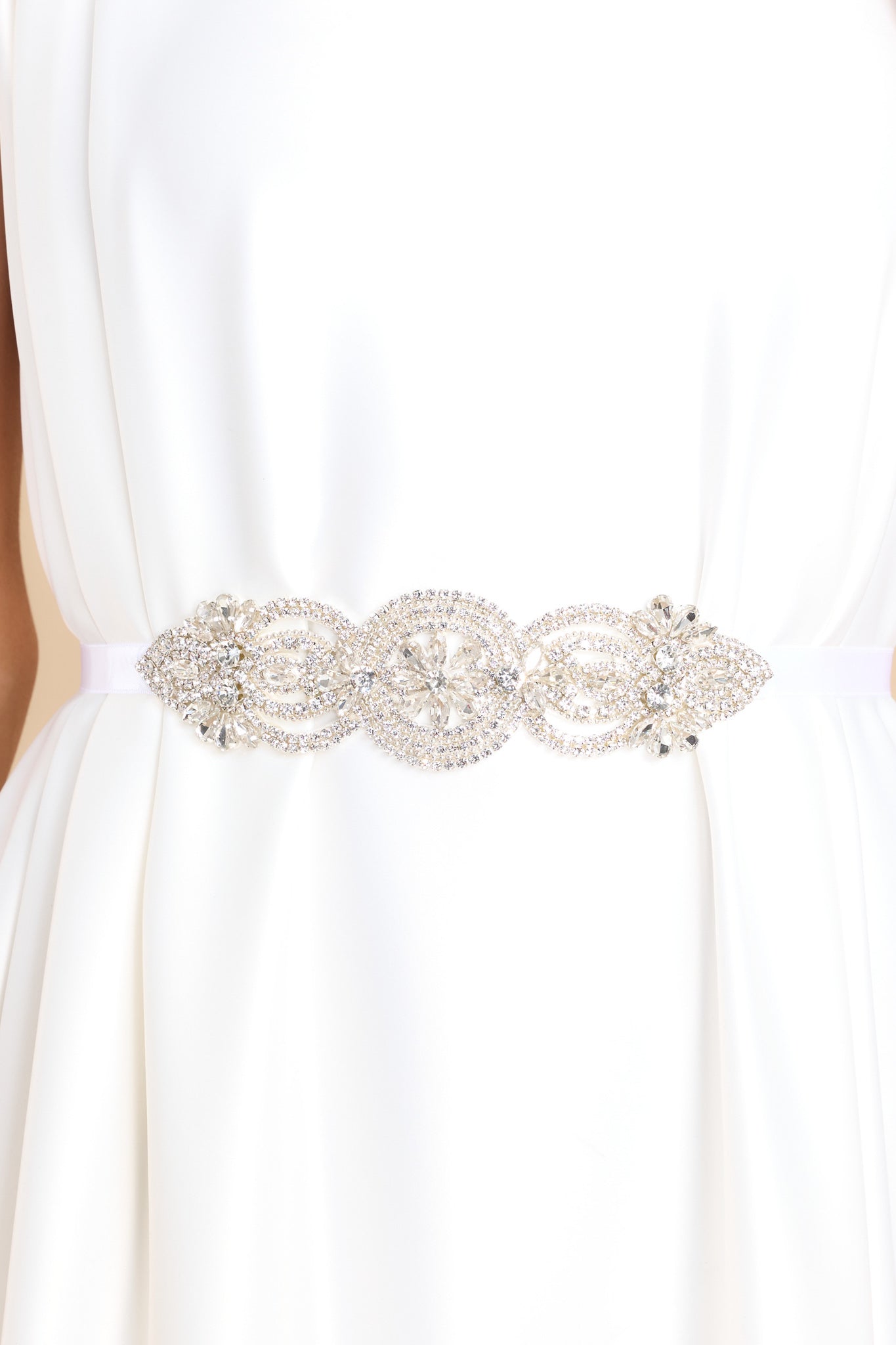 Front view of this belt that features a crystal centerpiece with floral details, and a self-tie ribbon closure.