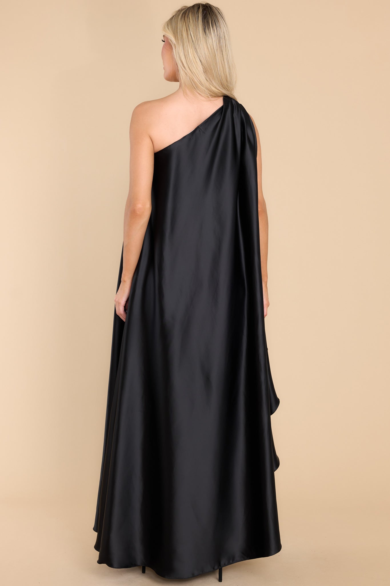 Back view of this dress that features a hidden one shoulder design, scoop neckline, and open sleeves.