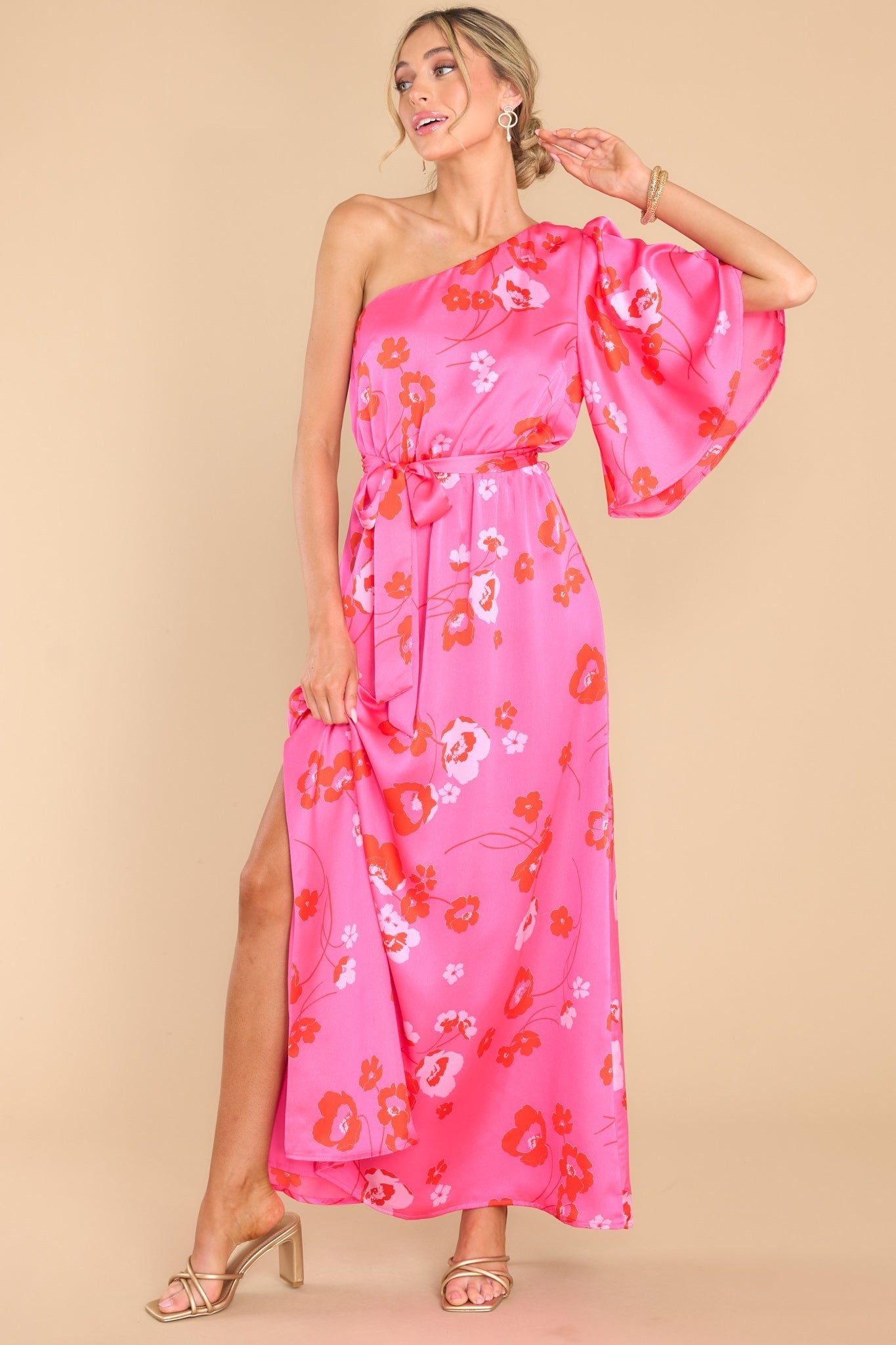 This hot pink dress features an asymmetrical one shoulder neckline, one butterfly sleeve, an elastic waistband with a self-tie belt, and a slit up the leg.