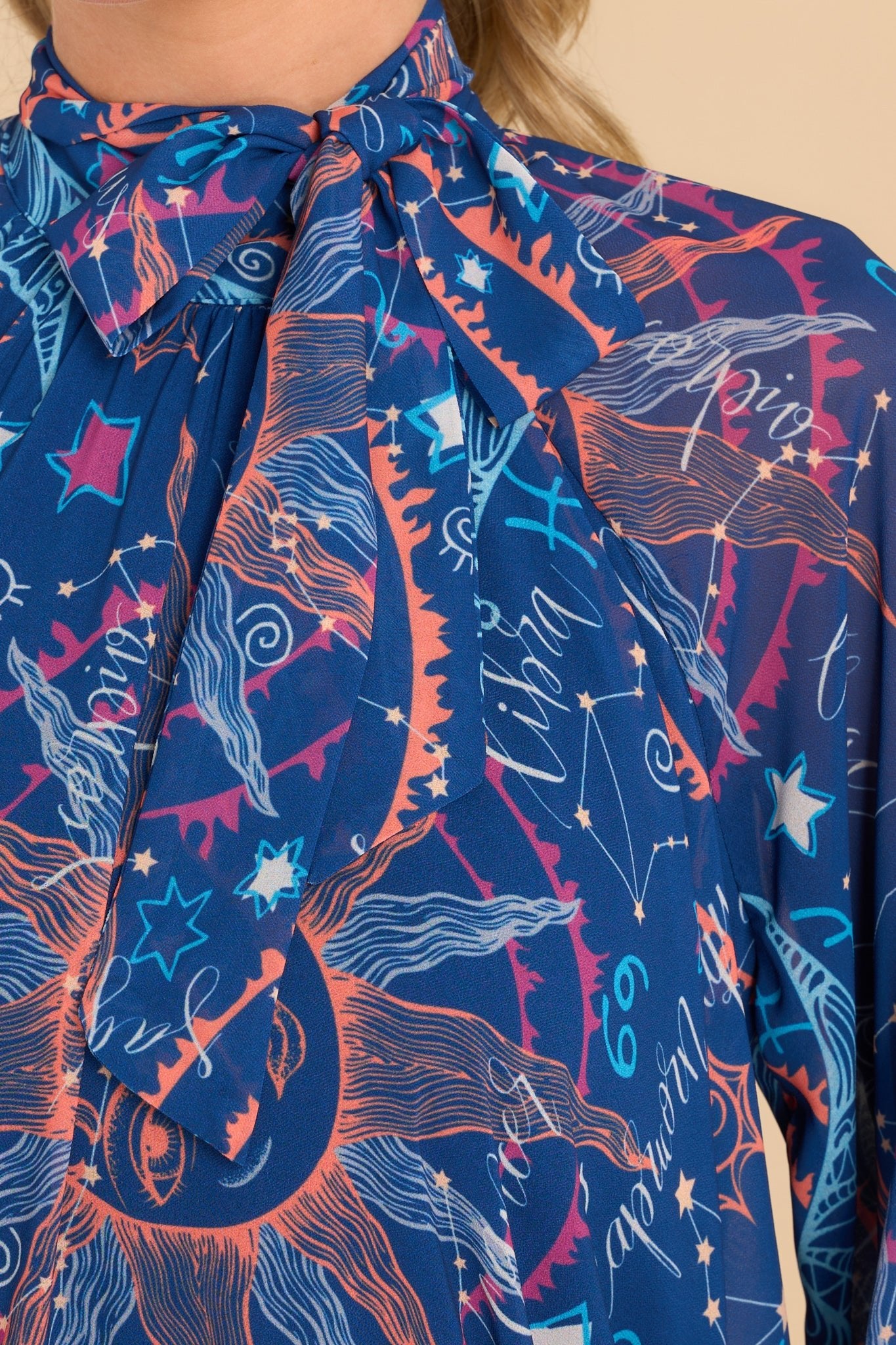 Close up view of this print dress features a halter neckline with a self-tie in the front.