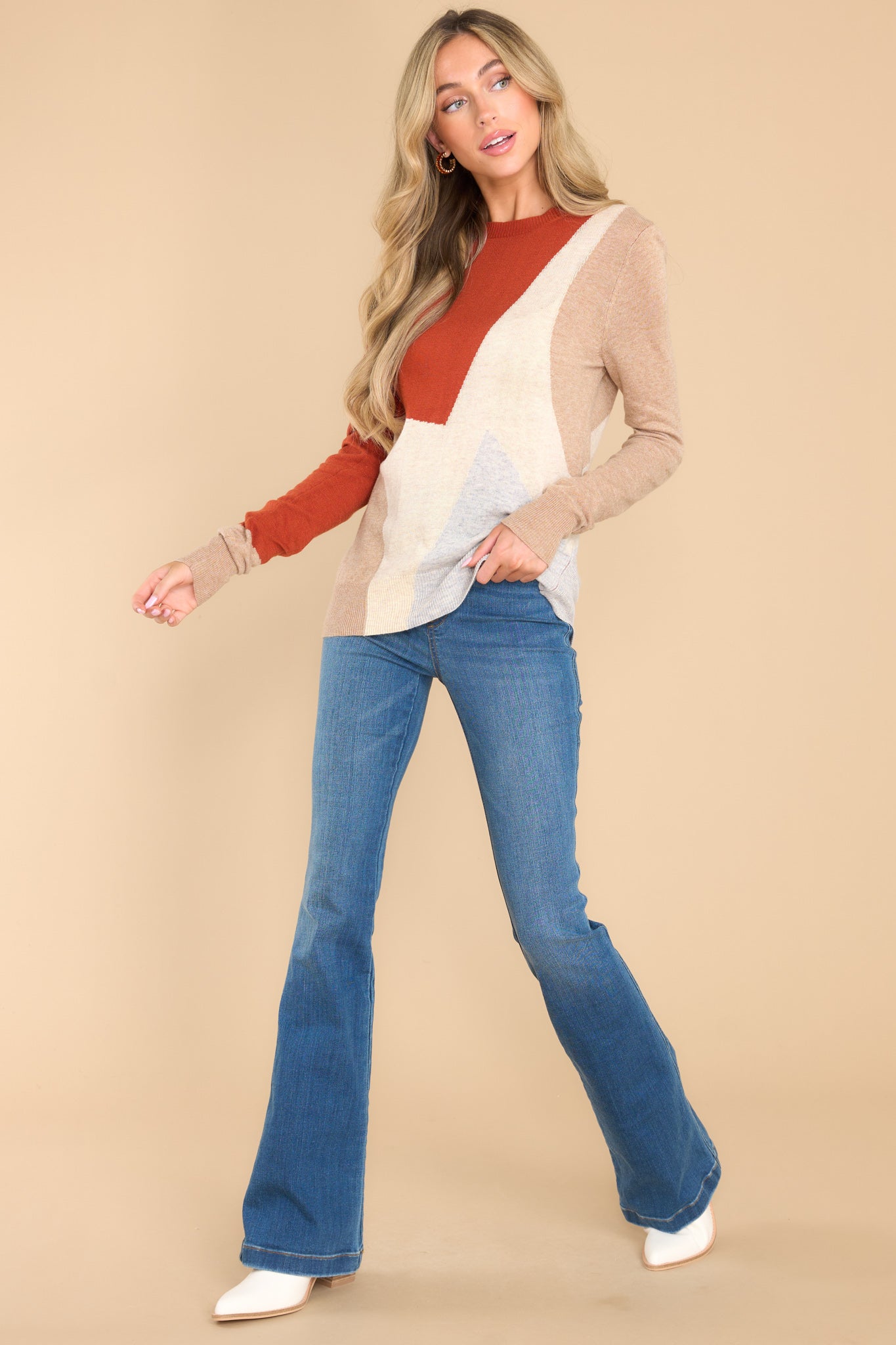 Full body view of this sweater that features a crew neckline, ribbed cuffs and hem, a multi-colored geometric pattern, and a soft knit material.