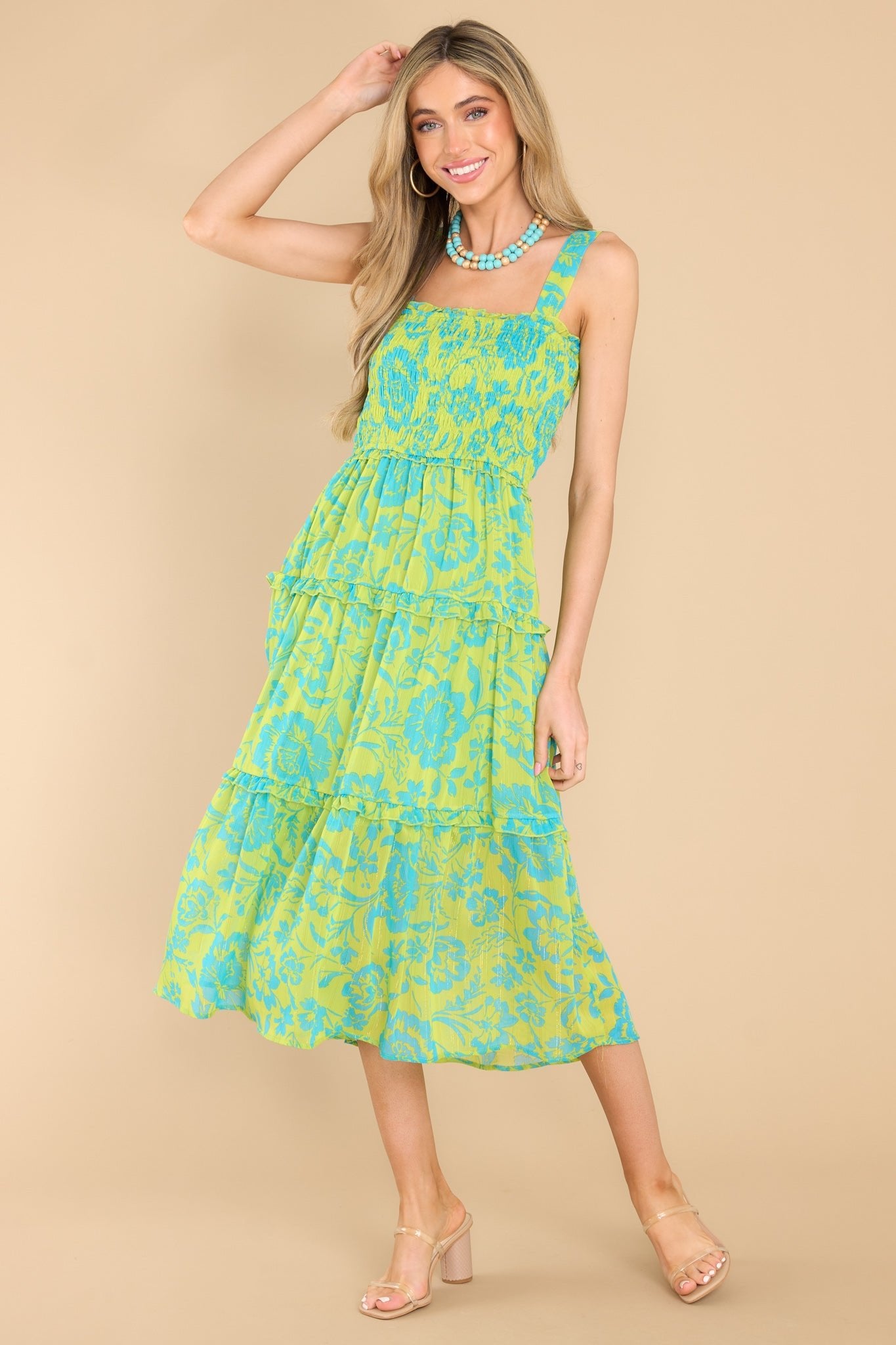 Full body view of this dress that showcases the blue floral pattern of the green fabric.