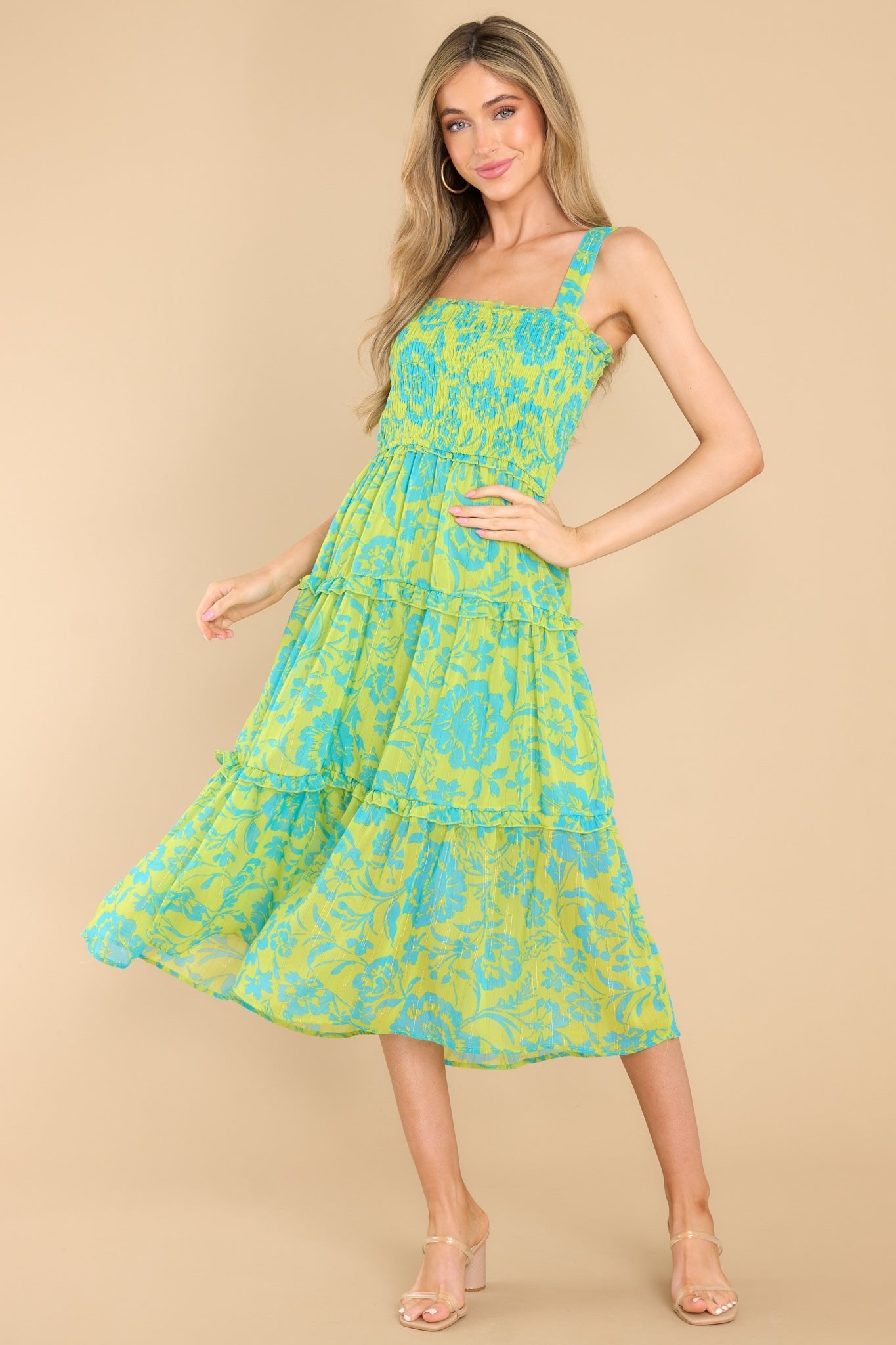 This green and blue dress features a square neckline with small ruffle detailing, tank straps with small elastics along the back that allow for some stretch, a fully smocked bust, and a flowy, tiered skirt.