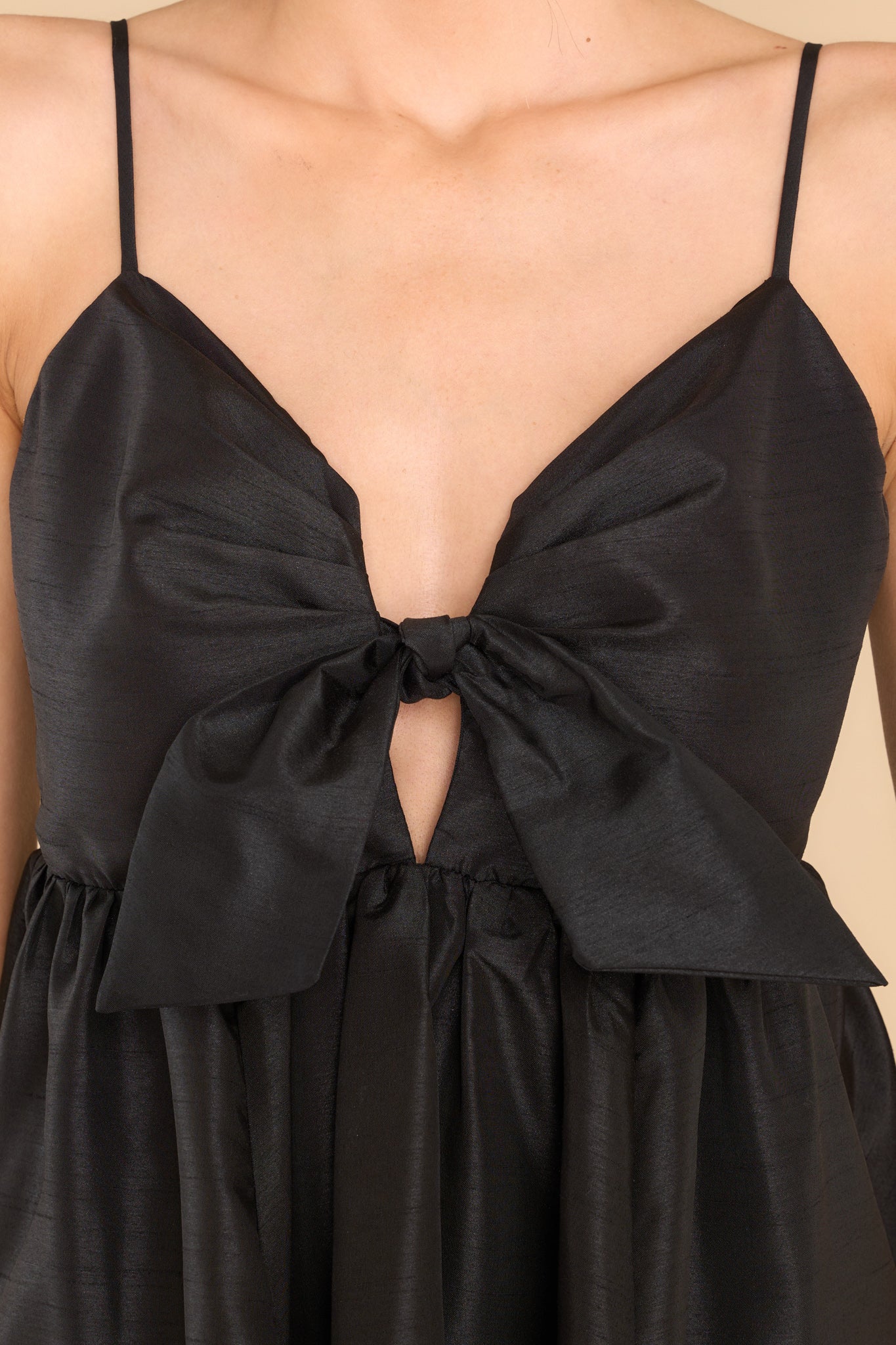 Close up view of this dress that features a sweetheart neckline with a key hole detail on the bust and a bow at the bust is non-adjustable.