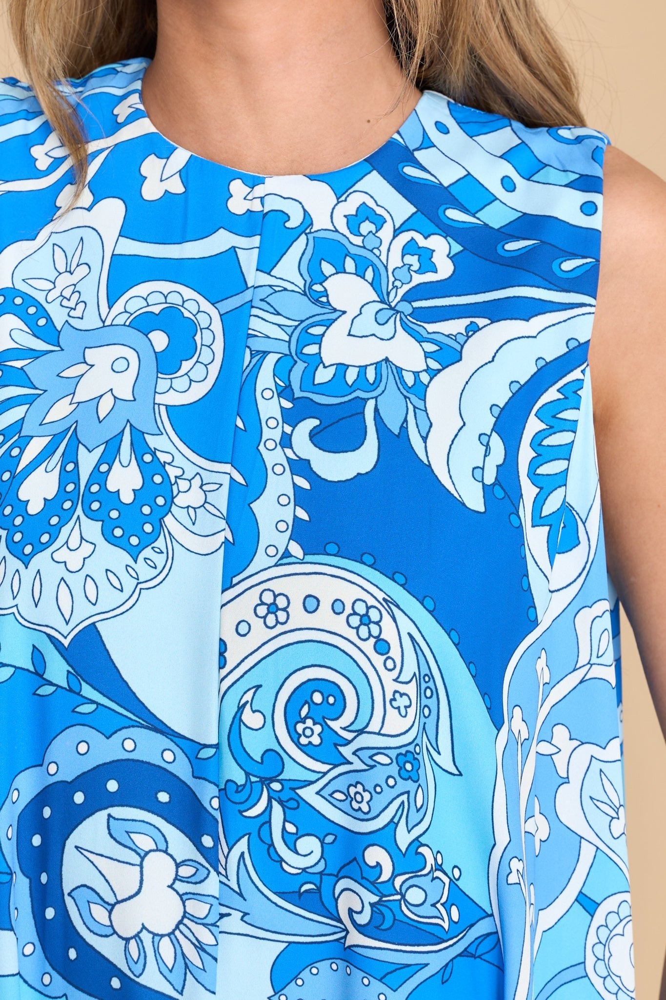 Close up view of this dress that features a round neckline, sleeveless design, and a bohemian print.