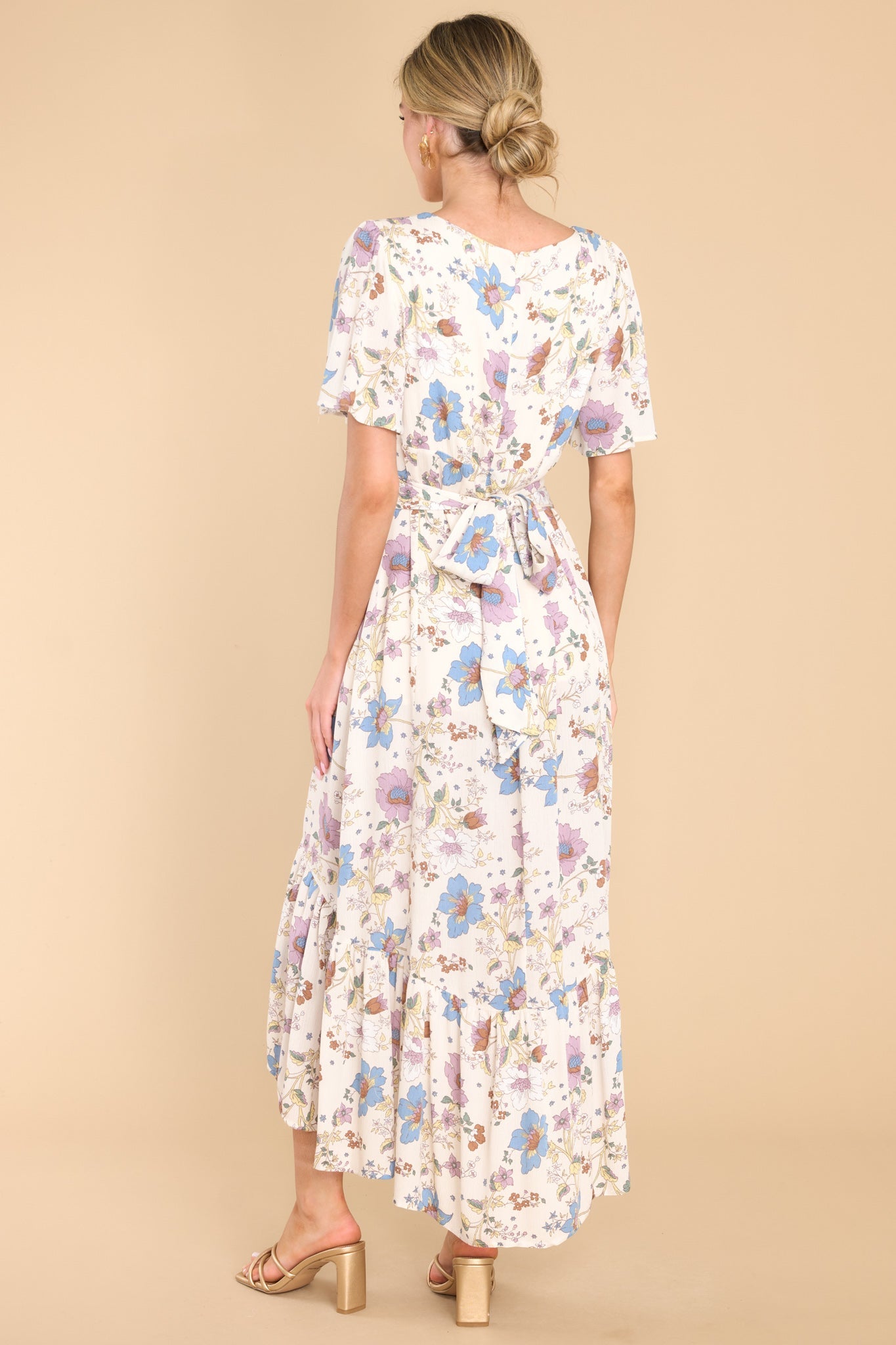 Back view of  this dress that features a v-neckline, butterfly sleeves, a zipper in the back, a self-tie at the back of the waistline, and a flowy skirt.