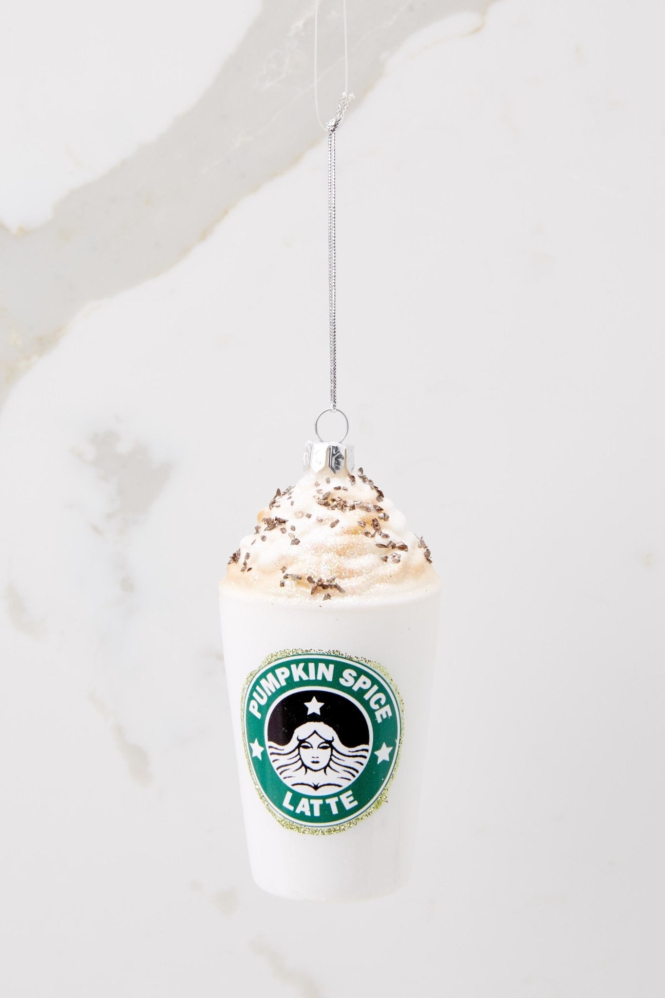 This white ornament features a pumpkin spice latte design with glitter details. 